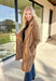 Timeless and cozy, this camel trench coat jacket by Haute Monde is a cold-weather essential you’ll reach for again and again. With a classic button front and side pockets, this piece brings effortless polish to any winter outfit. The soft fabric and tailored silhouette make it perfect for layering over chunky knits or dresses on chilly days.