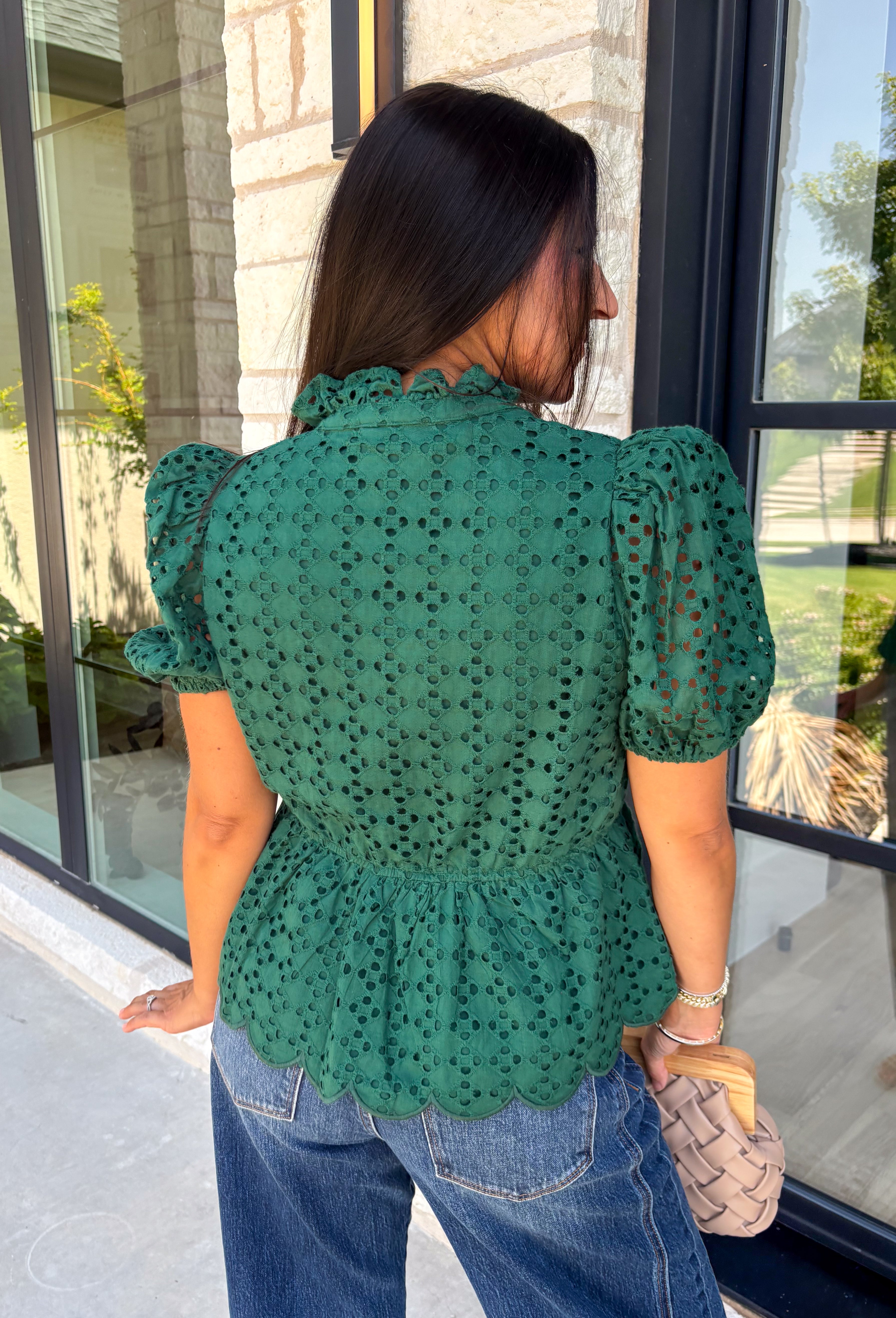 Elevate your fall wardrobe with this beautifully detailed hunter green top! Crafted from breathable cotton, this feminine top features intricate eyelet embroidery that adds timeless texture and charm. The ruffled accent neckline and flattering v-neck create an effortlessly polished look, while the button front and short puff sleeves with elastic cuffs offer both comfort and style. 