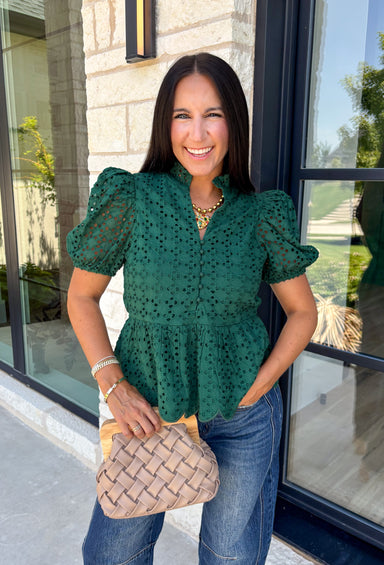 Elevate your fall wardrobe with this beautifully detailed hunter green top! Crafted from breathable cotton, this feminine top features intricate eyelet embroidery that adds timeless texture and charm. The ruffled accent neckline and flattering v-neck create an effortlessly polished look, while the button front and short puff sleeves with elastic cuffs offer both comfort and style. 