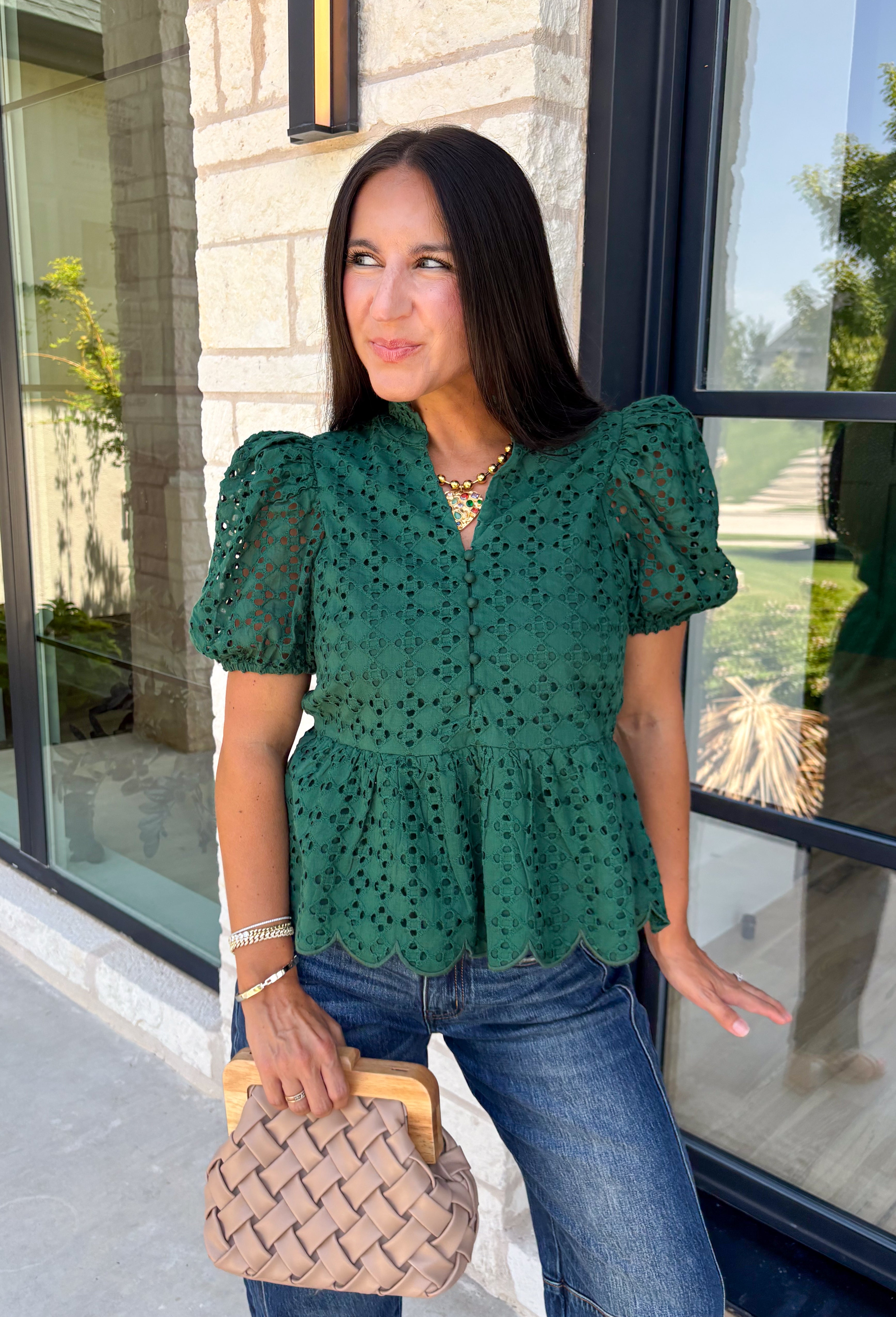 Elevate your fall wardrobe with this beautifully detailed hunter green top! Crafted from breathable cotton, this feminine top features intricate eyelet embroidery that adds timeless texture and charm. The ruffled accent neckline and flattering v-neck create an effortlessly polished look, while the button front and short puff sleeves with elastic cuffs offer both comfort and style. 