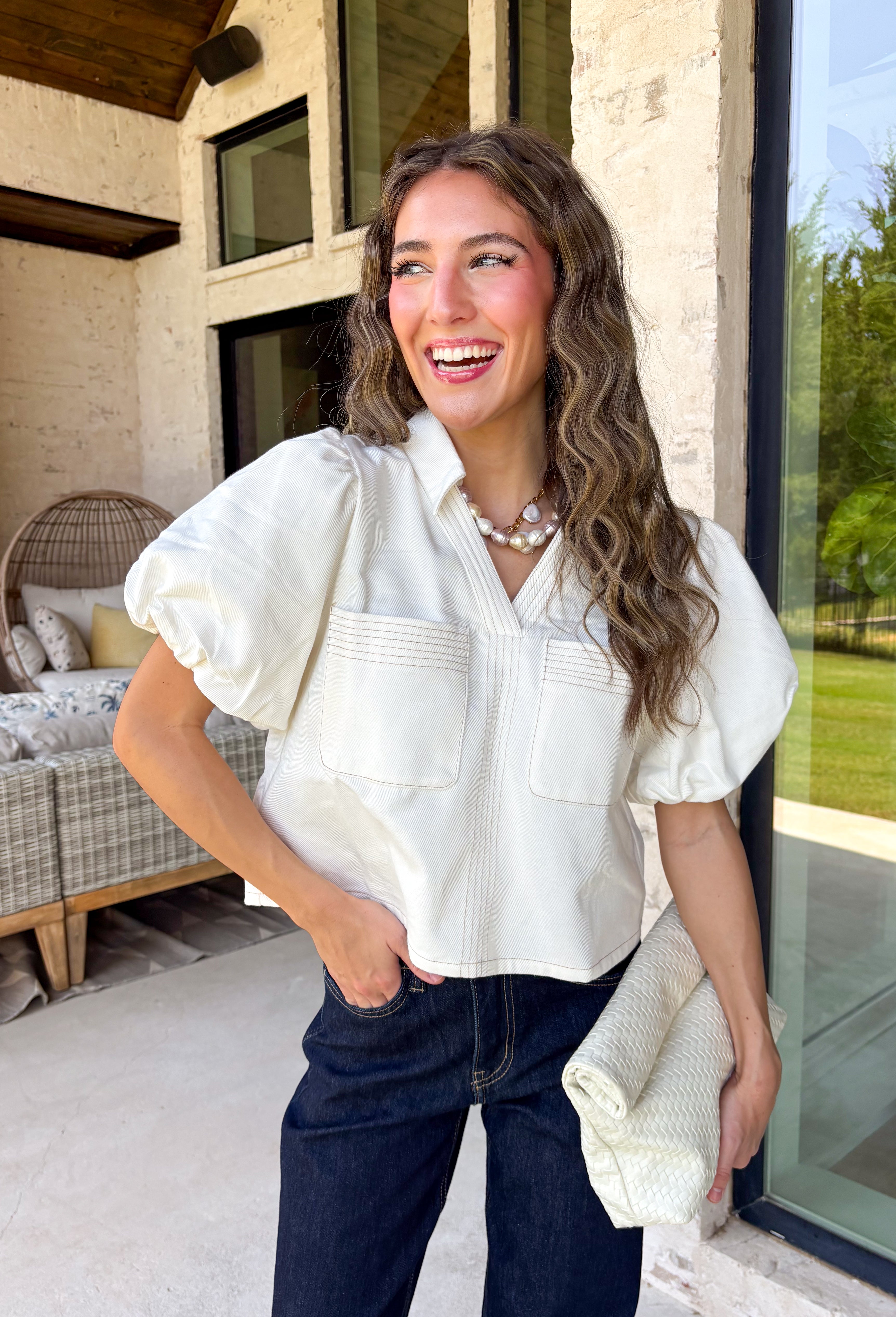 Every wardrobe needs a timeless white denim top, and this one is sure to become a favorite. Crafted from crisp 100% cotton, this classic piece features beautiful tan contrast stitching that adds warmth and dimension to the clean white denim. Feminine puff sleeves give this everyday staple a stylish update, while the collared neckline and front pockets keep the look polished and versatile. You'll find yourself reaching for this top constantly!