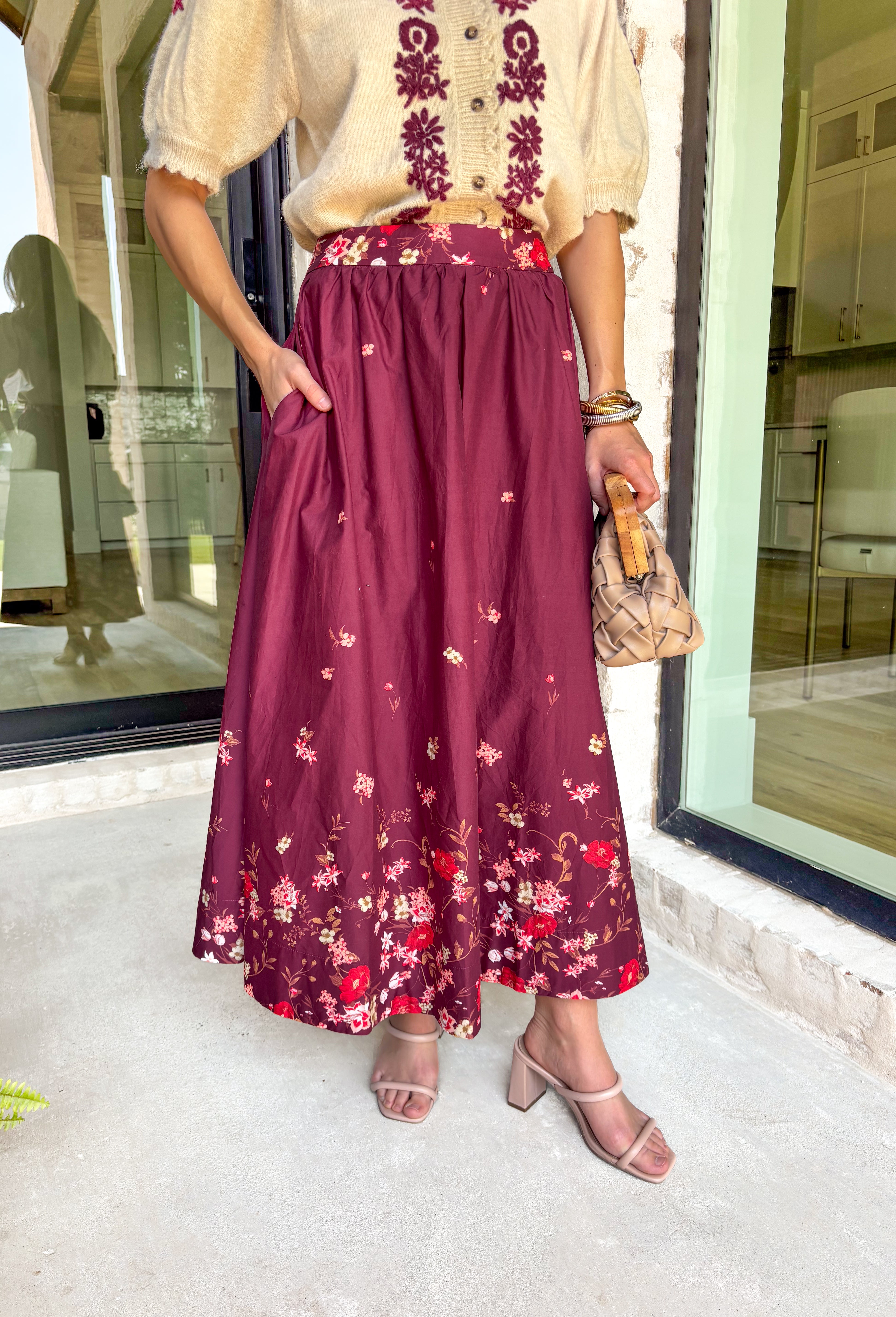 Feminine and flowy, this burgundy midi skirt is a seasonal standout. Designed with a floral border placement print, it adds just the right amount of charm while keeping the look timeless. The elasticated back waistband and side zipper closure make it comfortable and flattering, while side pockets add that everyday practicality we love. Fully lined in breathable cotton, this skirt is ready for everything from workdays to weekend strolls through the pumpkin patch.