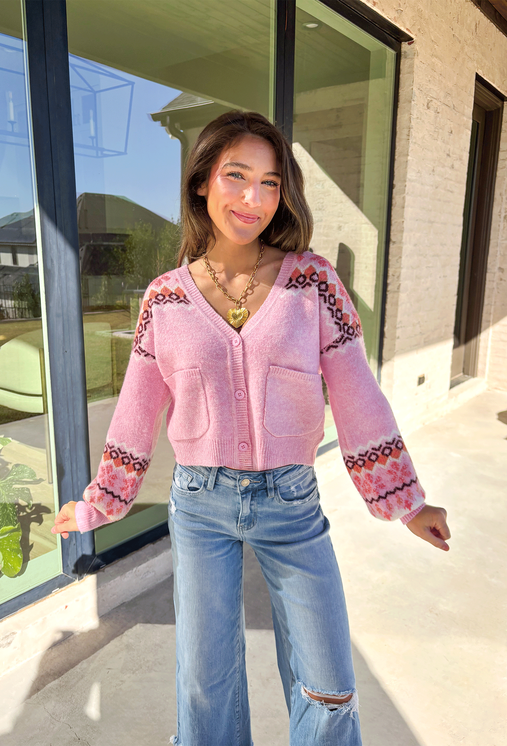 Sweet and cozy, this light pink cardigan by Skies Are Blue adds a touch of charm to your winter wardrobe. Featuring a soft Fair Isle pattern along the top and a cropped silhouette, this piece blends classic winter style with a playful twist. The front pockets and button-down design make it as functional as it is cute—perfect for layering on chilly days or adding warmth to festive outfits.
