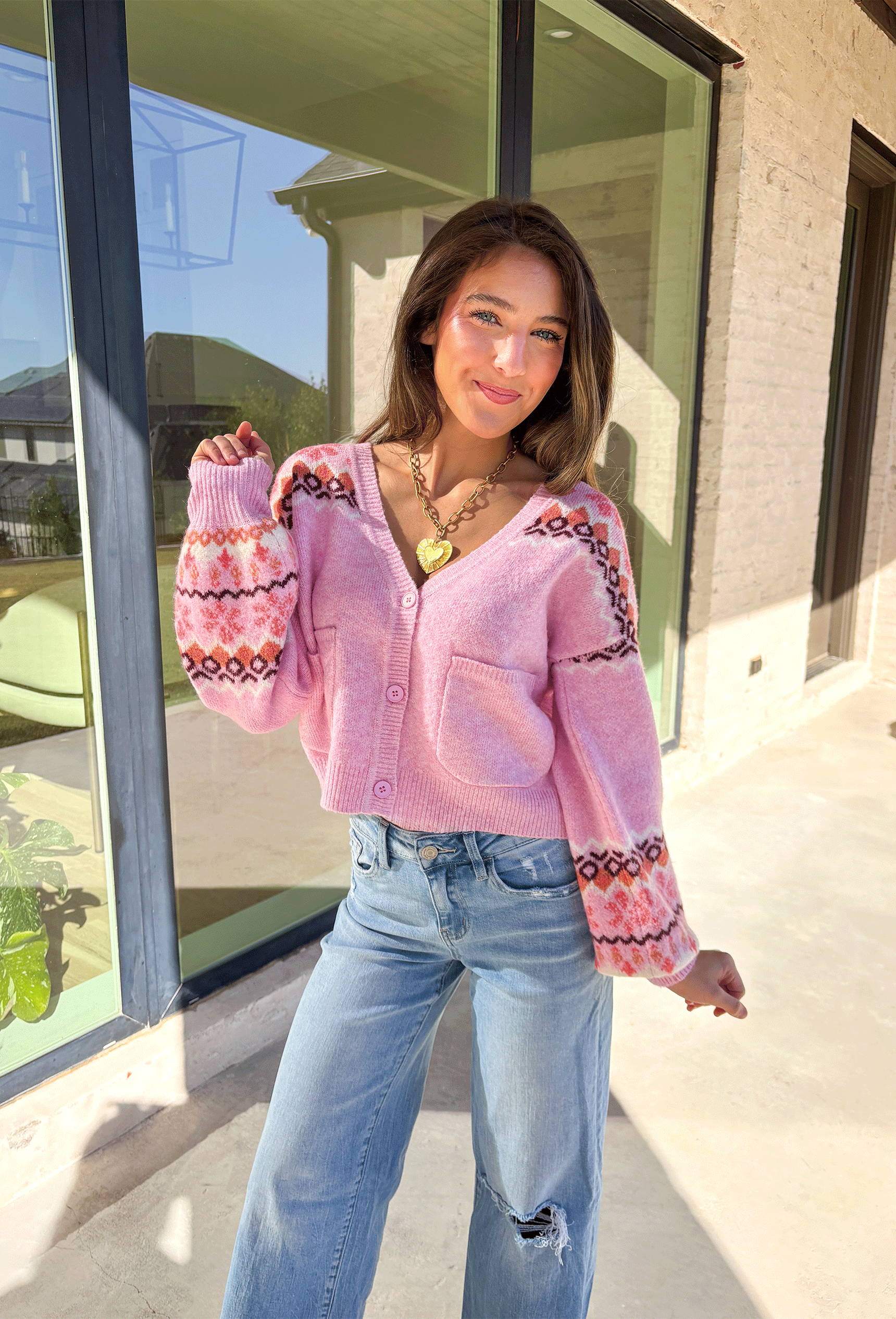 Sweet and cozy, this light pink cardigan by Skies Are Blue adds a touch of charm to your winter wardrobe. Featuring a soft Fair Isle pattern along the top and a cropped silhouette, this piece blends classic winter style with a playful twist. The front pockets and button-down design make it as functional as it is cute—perfect for layering on chilly days or adding warmth to festive outfits.