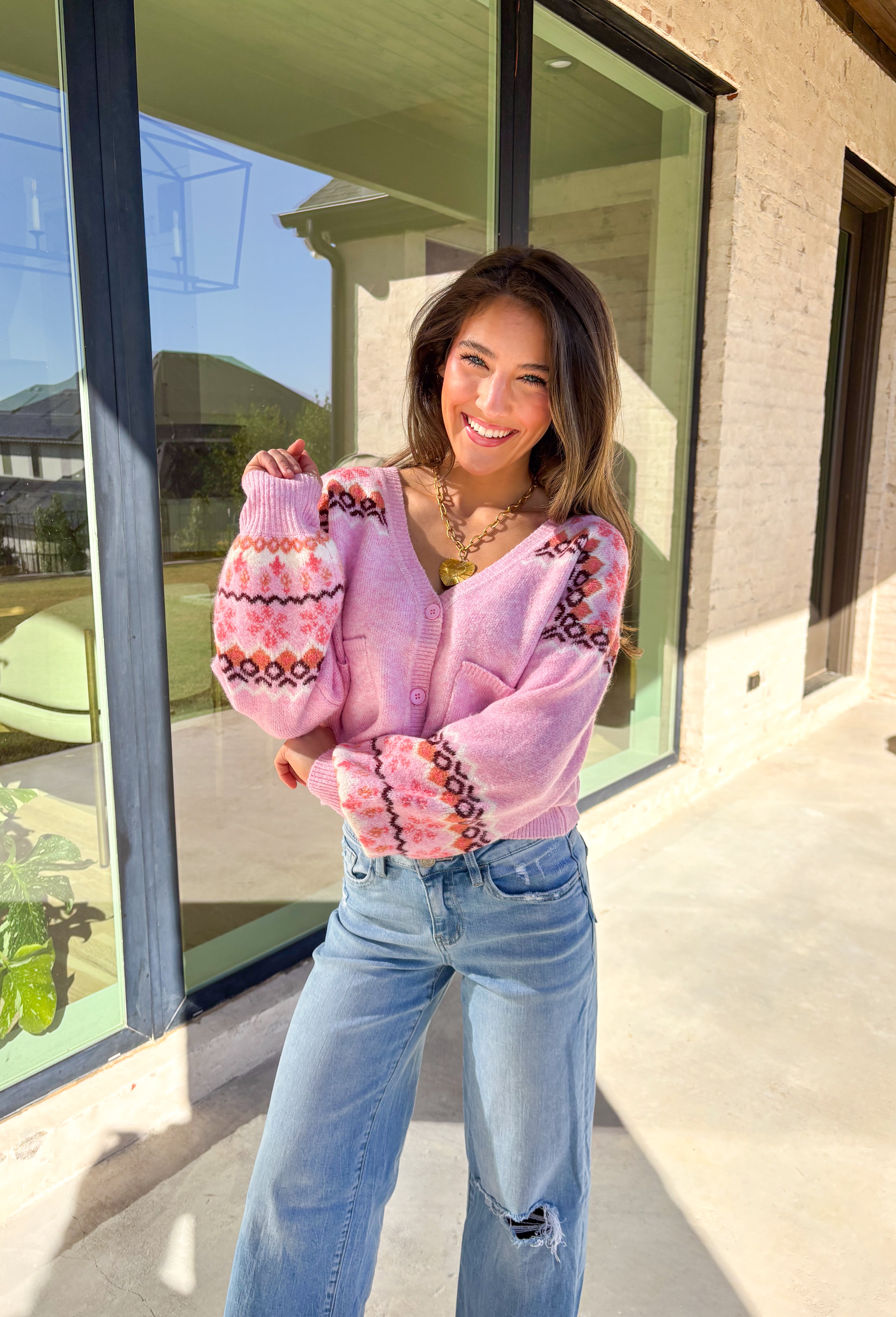 Sweet and cozy, this light pink cardigan by Skies Are Blue adds a touch of charm to your winter wardrobe. Featuring a soft Fair Isle pattern along the top and a cropped silhouette, this piece blends classic winter style with a playful twist. The front pockets and button-down design make it as functional as it is cute—perfect for layering on chilly days or adding warmth to festive outfits.