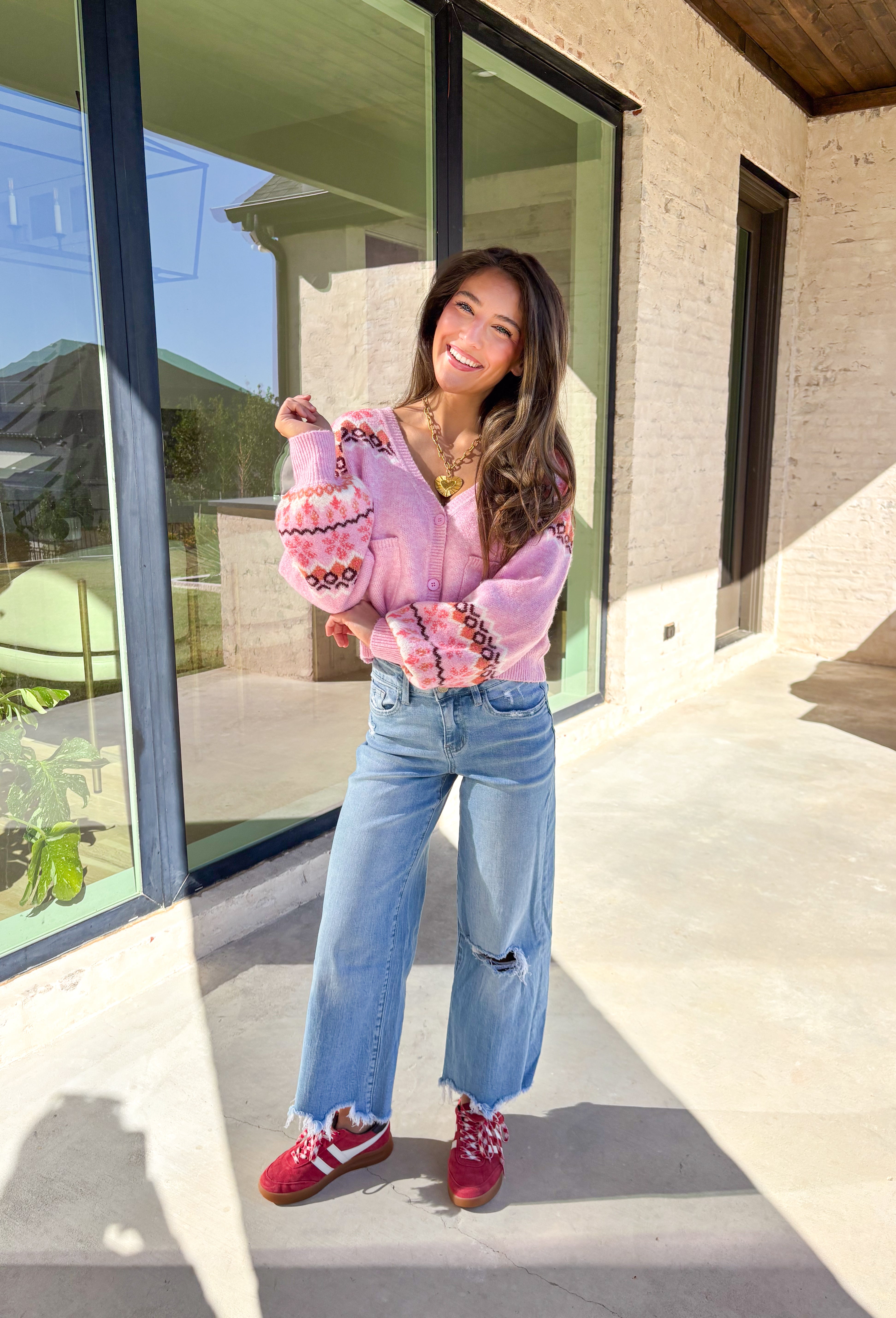 Sweet and cozy, this light pink cardigan by Skies Are Blue adds a touch of charm to your winter wardrobe. Featuring a soft Fair Isle pattern along the top and a cropped silhouette, this piece blends classic winter style with a playful twist. The front pockets and button-down design make it as functional as it is cute—perfect for layering on chilly days or adding warmth to festive outfits.