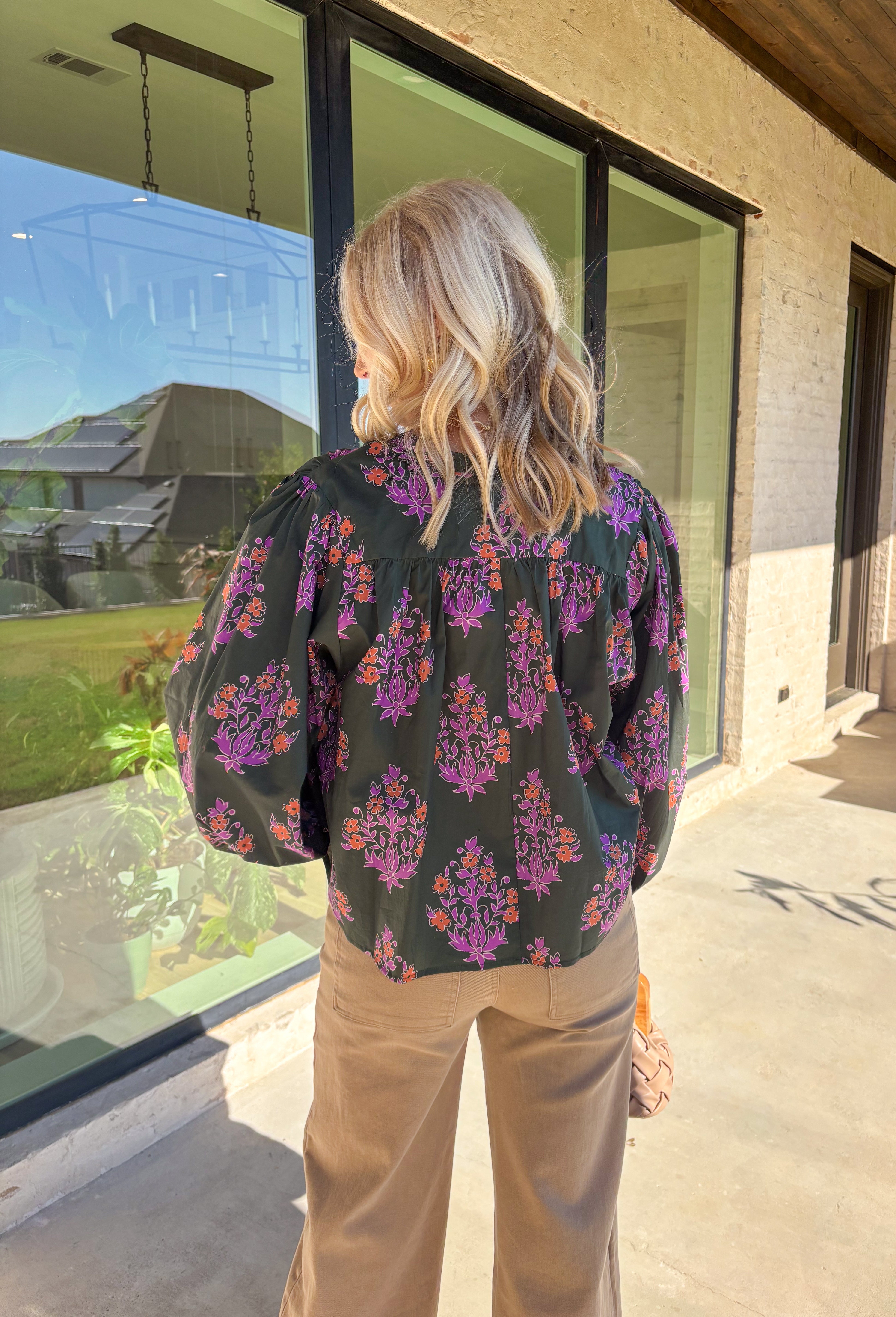 This dark green button-down top by Entro blends classic design with a seasonal twist. Featuring a lively orange and purple floral print, it adds just the right pop of color while keeping things effortless and chic. The breathable 100% cotton fabric makes it comfortable enough for everyday wear, and the button-front style gives you plenty of ways to layer and style it through the season. Perfect for bringing a touch of fall flair to your wardrobe.