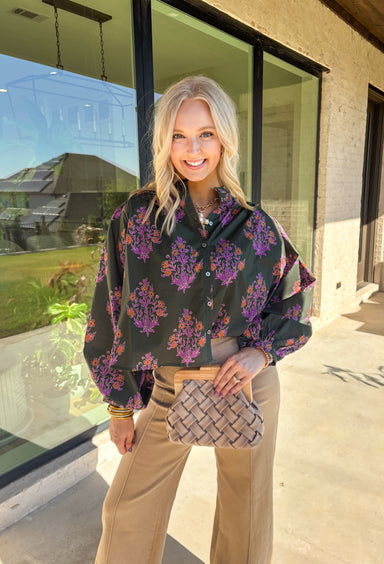 This dark green button-down top by Entro blends classic design with a seasonal twist. Featuring a lively orange and purple floral print, it adds just the right pop of color while keeping things effortless and chic. The breathable 100% cotton fabric makes it comfortable enough for everyday wear, and the button-front style gives you plenty of ways to layer and style it through the season. Perfect for bringing a touch of fall flair to your wardrobe.