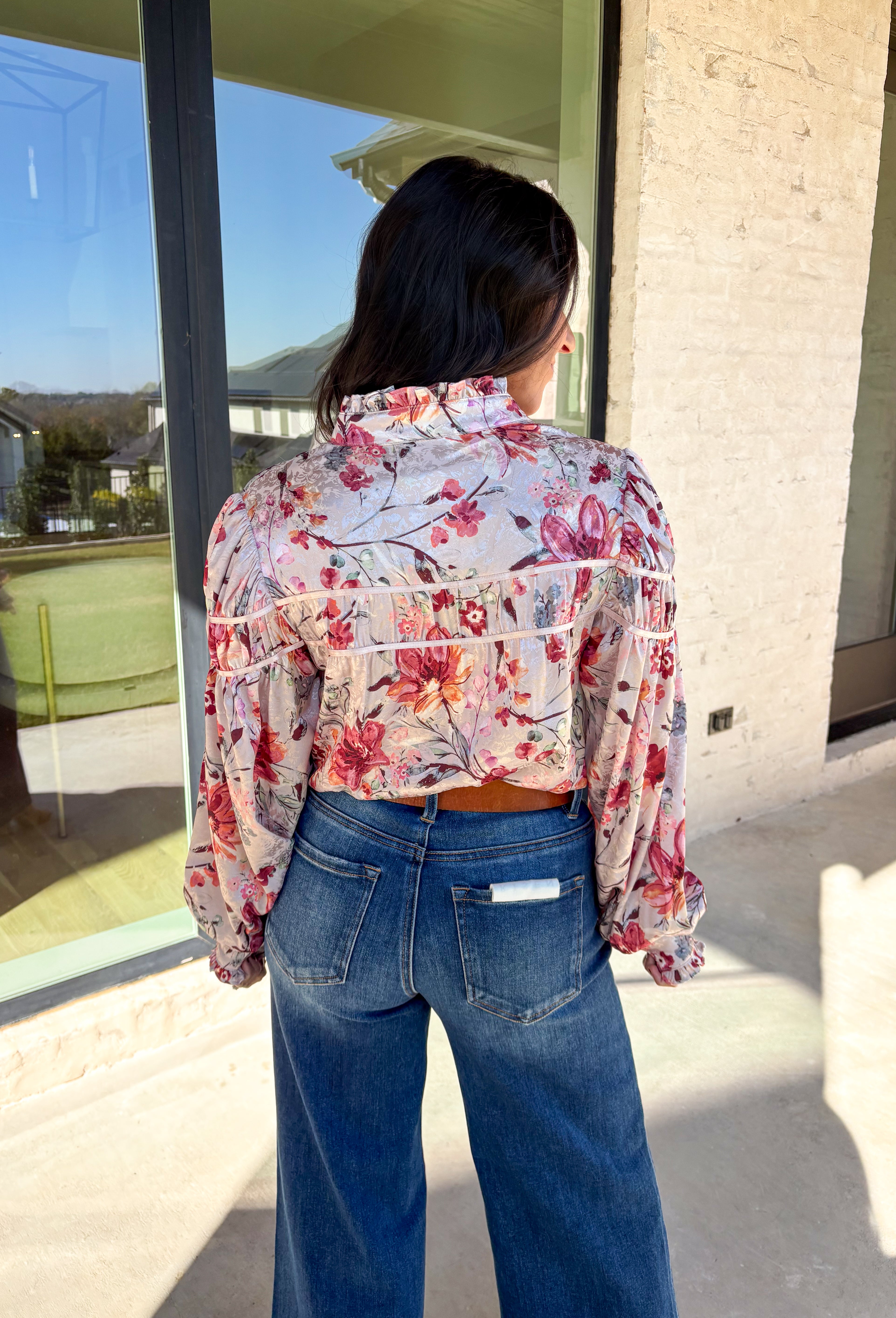 Bring a touch of winter romance to your wardrobe with this mauve floral button-down top by Fate. Featuring shades of pink, burgundy, gray, and orange, the floral print adds a warm pop of color against the chilly season. The ruffled neckline and cuffs give it a soft, feminine finish—perfect for dressing up denim or layering under a structured jacket all winter long.