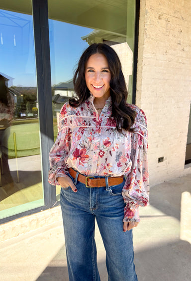 Bring a touch of winter romance to your wardrobe with this mauve floral button-down top by Fate. Featuring shades of pink, burgundy, gray, and orange, the floral print adds a warm pop of color against the chilly season. The ruffled neckline and cuffs give it a soft, feminine finish—perfect for dressing up denim or layering under a structured jacket all winter long.