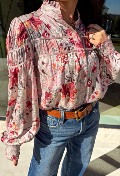 Bring a touch of winter romance to your wardrobe with this mauve floral button-down top by Fate. Featuring shades of pink, burgundy, gray, and orange, the floral print adds a warm pop of color against the chilly season. The ruffled neckline and cuffs give it a soft, feminine finish—perfect for dressing up denim or layering under a structured jacket all winter long.