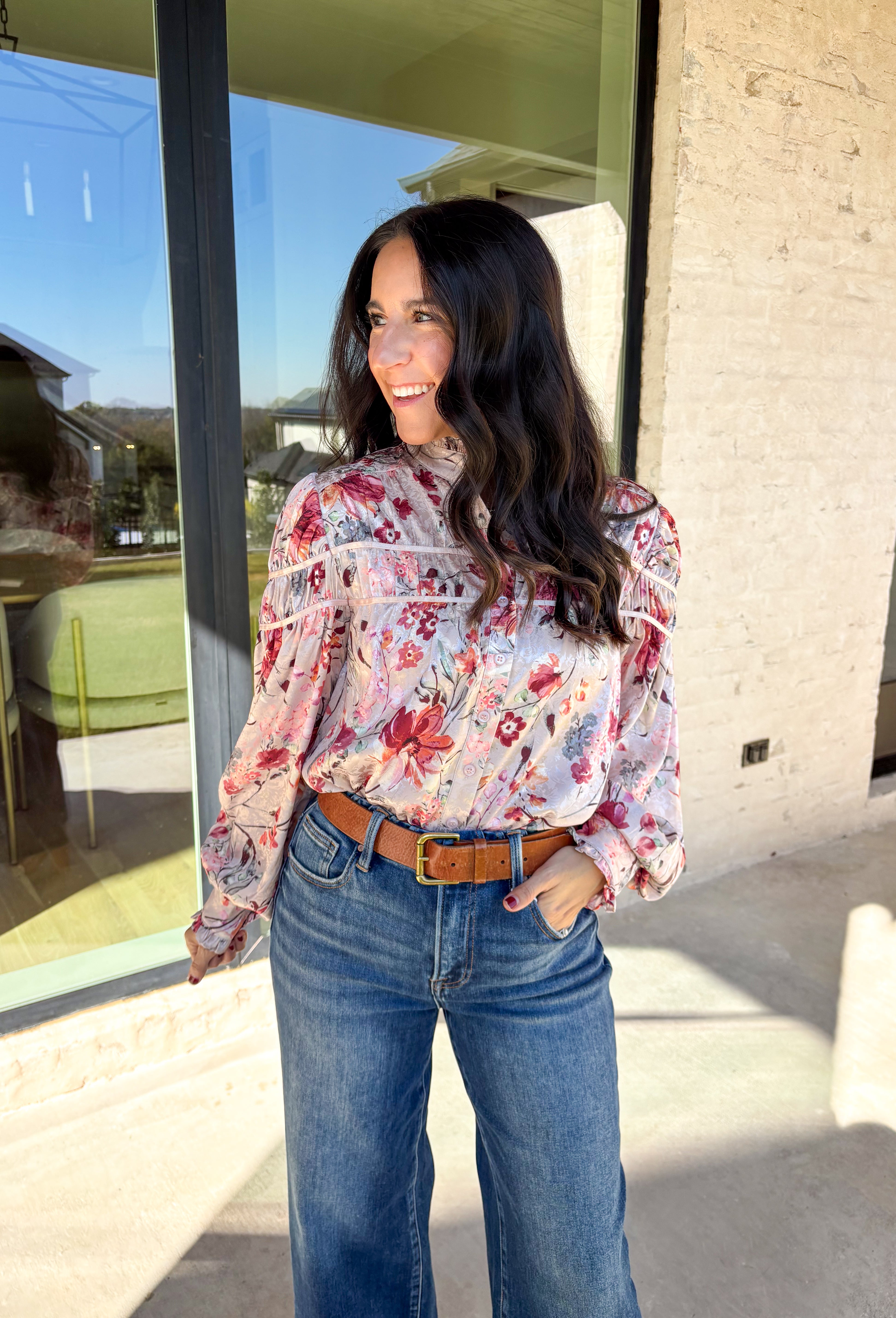 Bring a touch of winter romance to your wardrobe with this mauve floral button-down top by Fate. Featuring shades of pink, burgundy, gray, and orange, the floral print adds a warm pop of color against the chilly season. The ruffled neckline and cuffs give it a soft, feminine finish—perfect for dressing up denim or layering under a structured jacket all winter long.