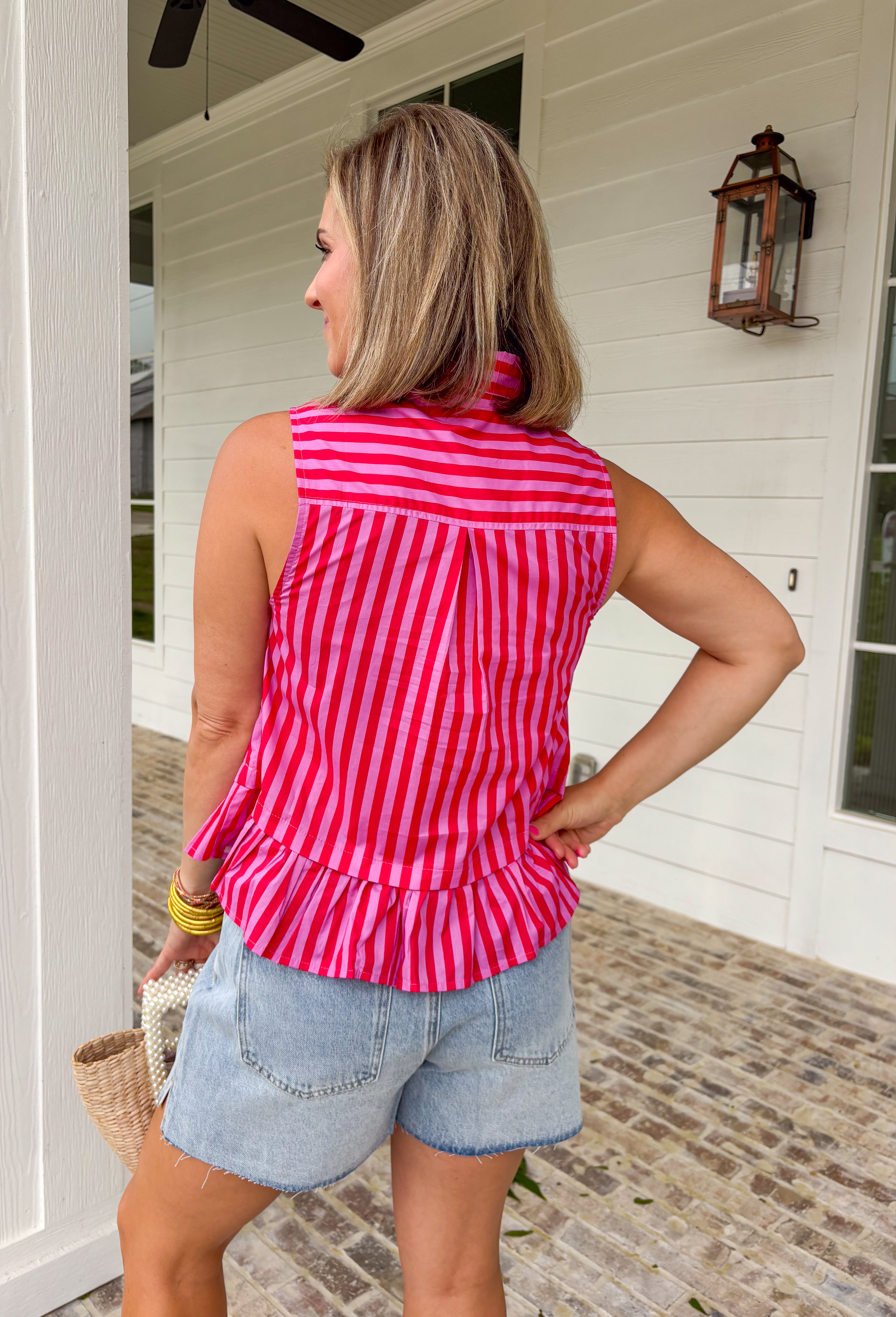 This pink and red striped peplum top is bringing all the fun, feminine summer vibes. The bold stripe combo makes such a statement, while the peplum silhouette creates a flattering, easy-to-wear shape. The tie neck detail and button front add that extra touch of charm, and the ruffle hem keeps it light and playful. Made from breathable cotton, it’s perfect for warm days when you still want to feel put together. Pair it with white denim or shorts.