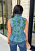 Bring a fresh pop of color to your fall wardrobe with this effortlessly charming paisley top. Featuring a beautiful green backdrop with a light blue paisley print, this sleeveless blouse is equal parts classic and feminine. The ruffled neckline and button-front details add a polished touch, while the peplum hem creates a flattering silhouette that's easy to wear from workdays to weekends. 