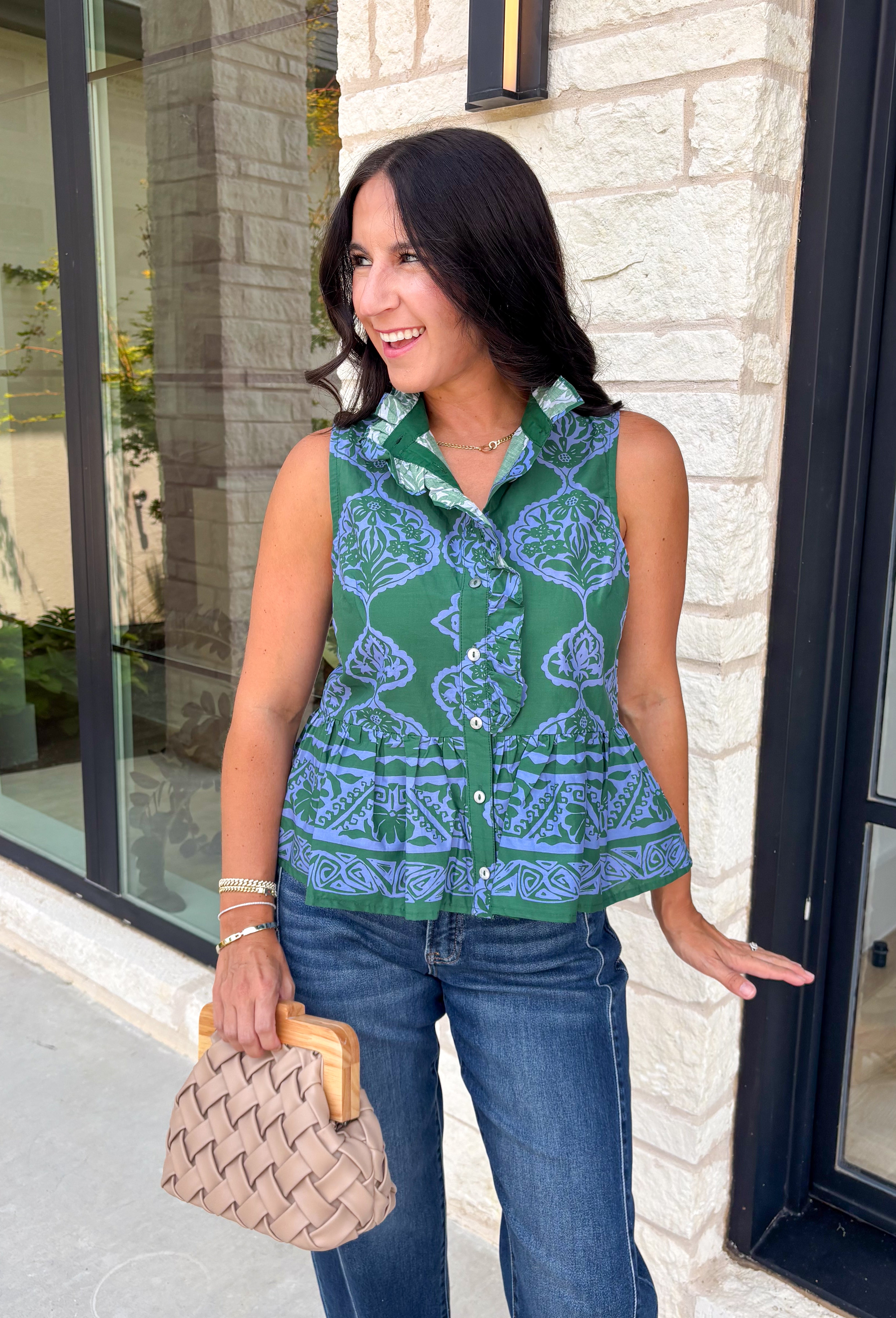 Bring a fresh pop of color to your fall wardrobe with this effortlessly charming paisley top. Featuring a beautiful green backdrop with a light blue paisley print, this sleeveless blouse is equal parts classic and feminine. The ruffled neckline and button-front details add a polished touch, while the peplum hem creates a flattering silhouette that's easy to wear from workdays to weekends. 