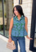Bring a fresh pop of color to your fall wardrobe with this effortlessly charming paisley top. Featuring a beautiful green backdrop with a light blue paisley print, this sleeveless blouse is equal parts classic and feminine. The ruffled neckline and button-front details add a polished touch, while the peplum hem creates a flattering silhouette that's easy to wear from workdays to weekends. 