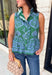 Bring a fresh pop of color to your fall wardrobe with this effortlessly charming paisley top. Featuring a beautiful green backdrop with a light blue paisley print, this sleeveless blouse is equal parts classic and feminine. The ruffled neckline and button-front details add a polished touch, while the peplum hem creates a flattering silhouette that's easy to wear from workdays to weekends. 