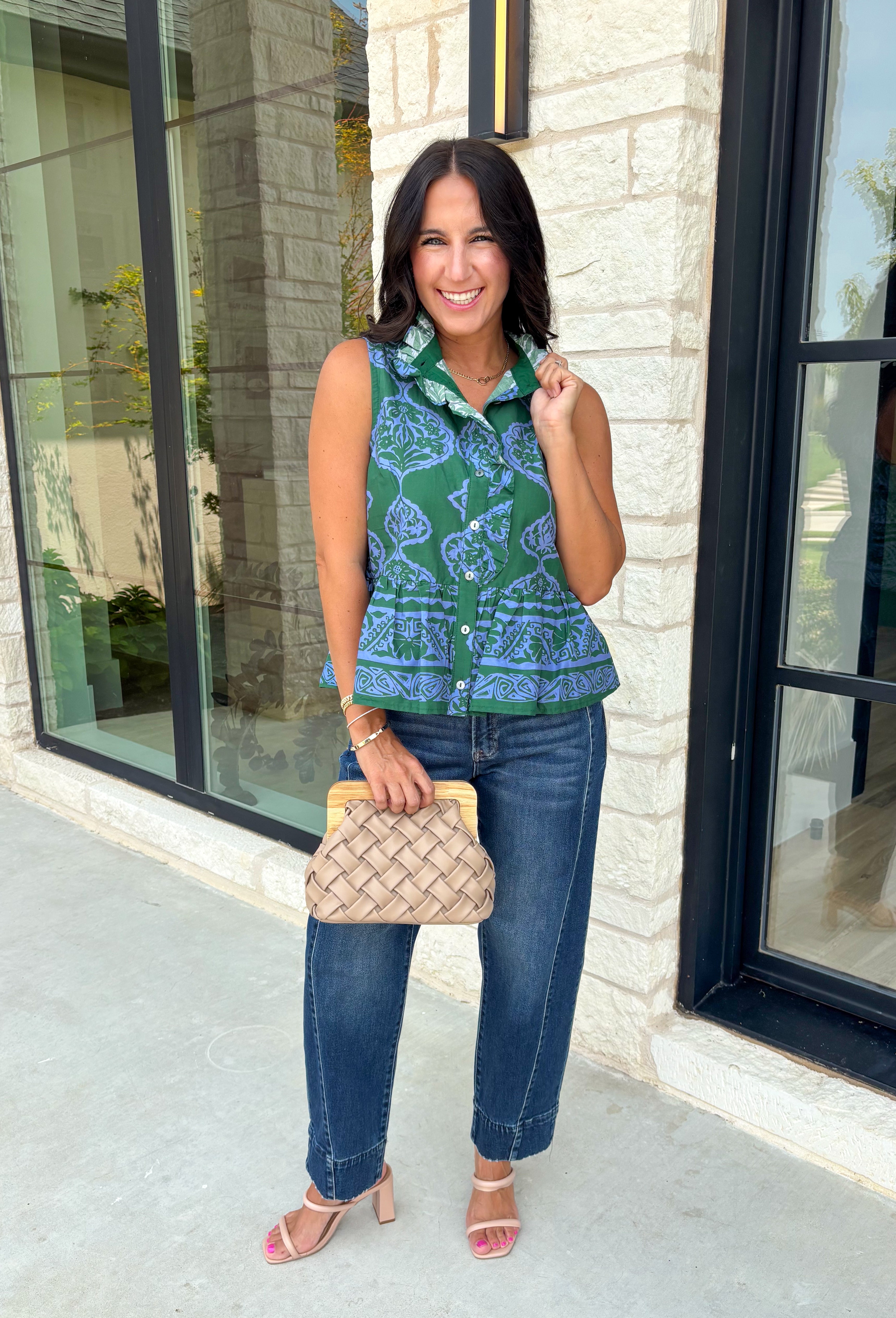 Bring a fresh pop of color to your fall wardrobe with this effortlessly charming paisley top. Featuring a beautiful green backdrop with a light blue paisley print, this sleeveless blouse is equal parts classic and feminine. The ruffled neckline and button-front details add a polished touch, while the peplum hem creates a flattering silhouette that's easy to wear from workdays to weekends. 