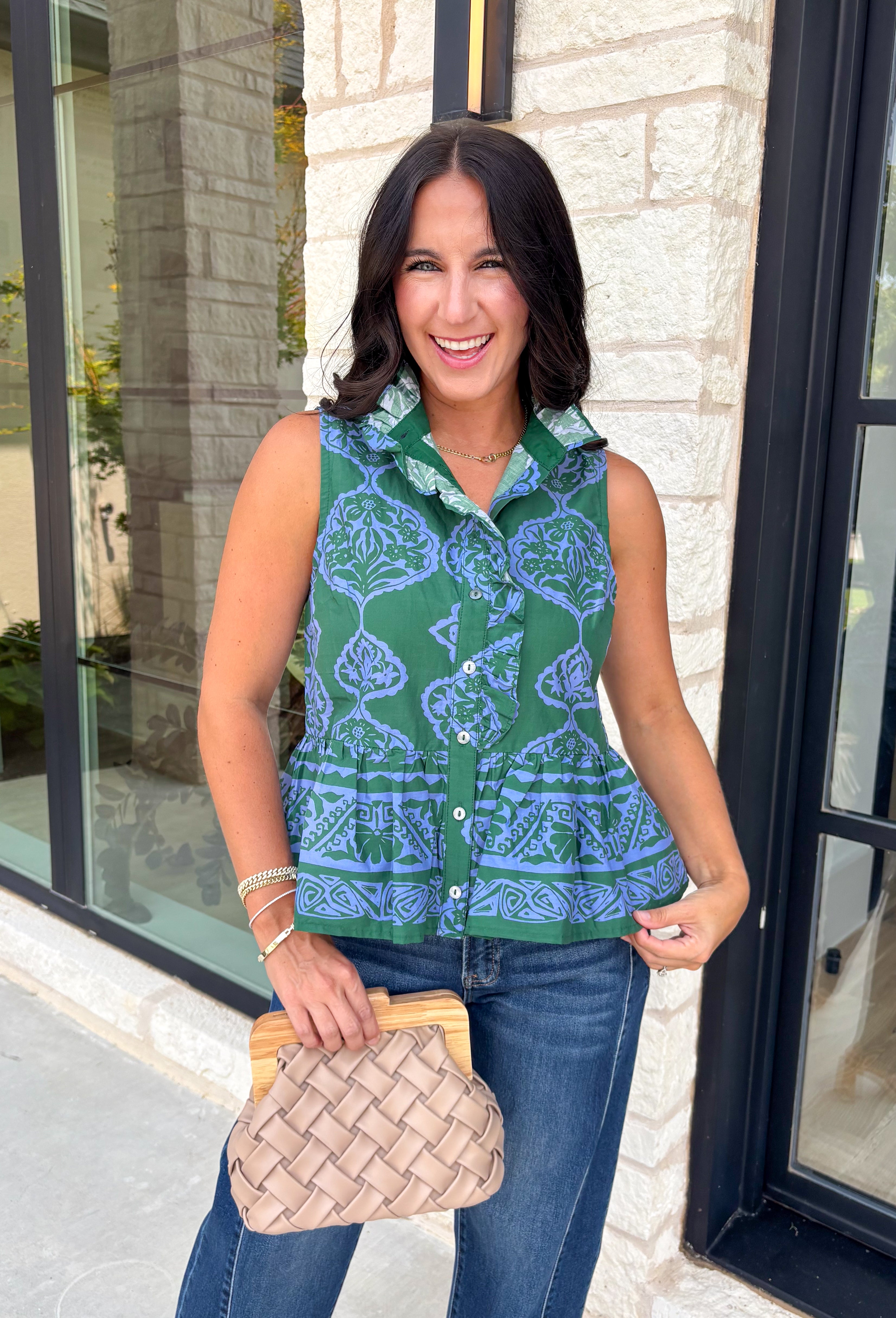 Bring a fresh pop of color to your fall wardrobe with this effortlessly charming paisley top. Featuring a beautiful green backdrop with a light blue paisley print, this sleeveless blouse is equal parts classic and feminine. The ruffled neckline and button-front details add a polished touch, while the peplum hem creates a flattering silhouette that's easy to wear from workdays to weekends. 