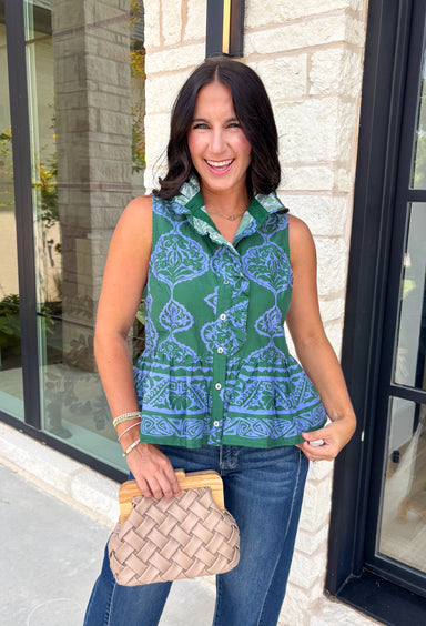 Bring a fresh pop of color to your fall wardrobe with this effortlessly charming paisley top. Featuring a beautiful green backdrop with a light blue paisley print, this sleeveless blouse is equal parts classic and feminine. The ruffled neckline and button-front details add a polished touch, while the peplum hem creates a flattering silhouette that's easy to wear from workdays to weekends. 