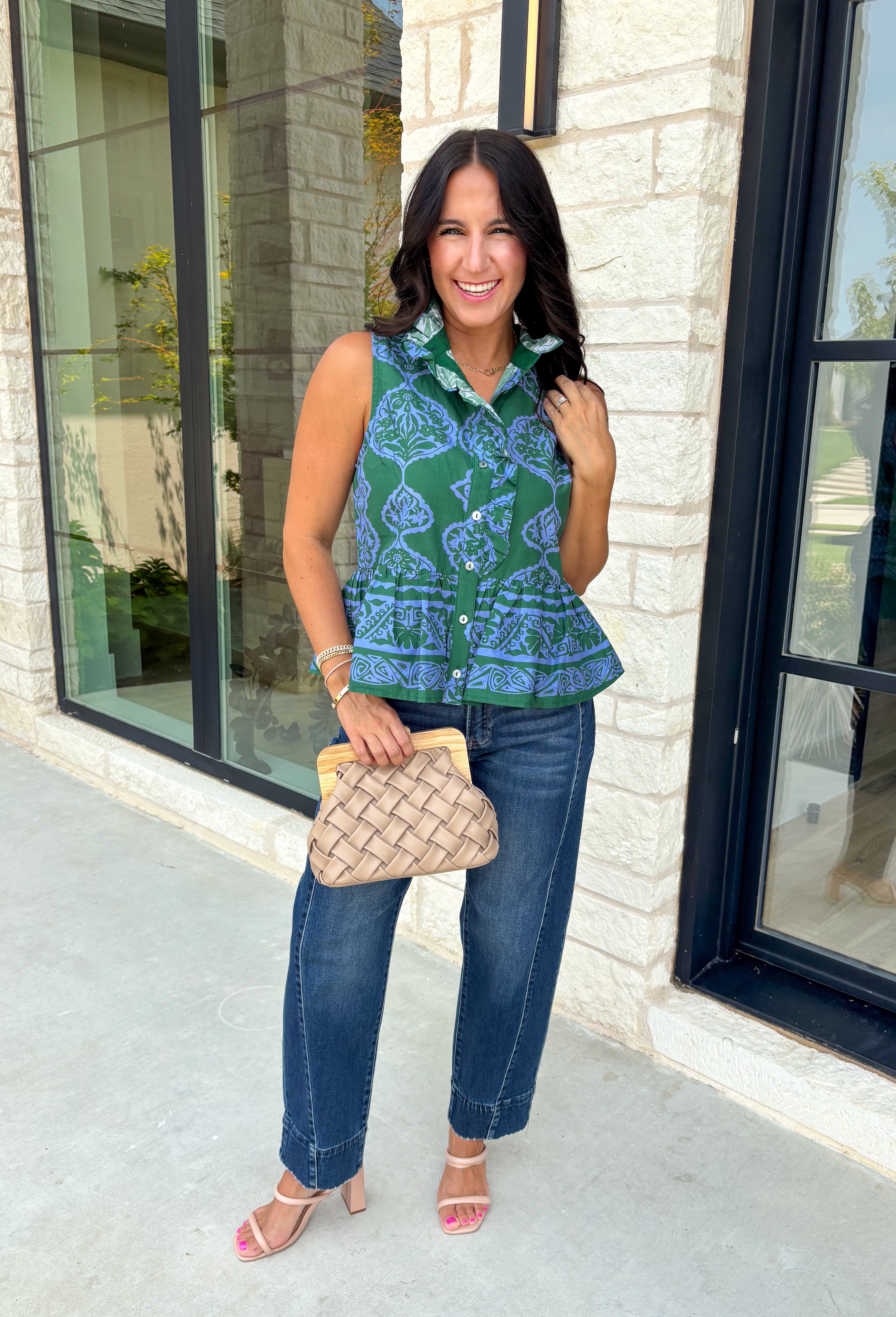 Bring a fresh pop of color to your fall wardrobe with this effortlessly charming paisley top. Featuring a beautiful green backdrop with a light blue paisley print, this sleeveless blouse is equal parts classic and feminine. The ruffled neckline and button-front details add a polished touch, while the peplum hem creates a flattering silhouette that's easy to wear from workdays to weekends. 