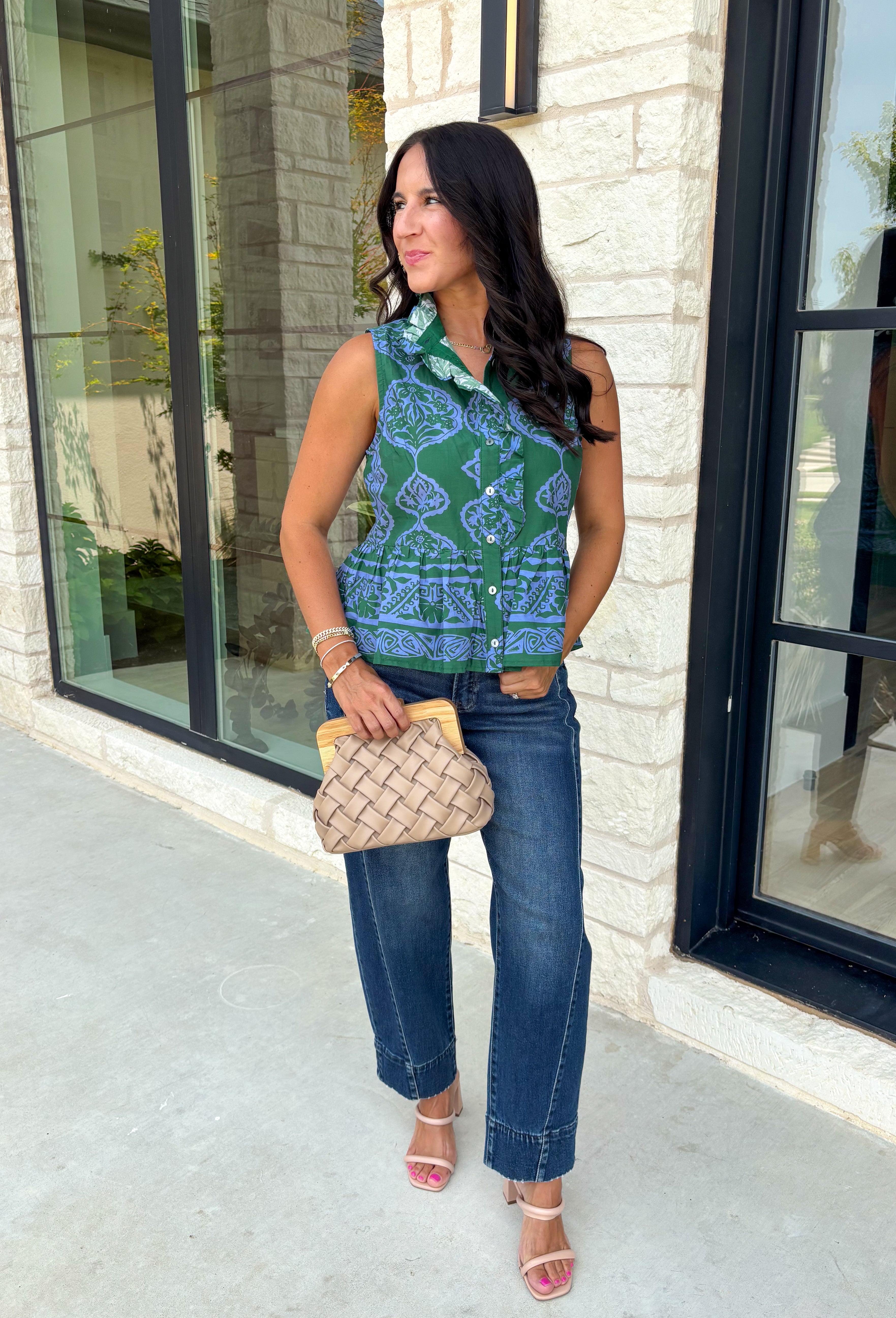 Bring a fresh pop of color to your fall wardrobe with this effortlessly charming paisley top. Featuring a beautiful green backdrop with a light blue paisley print, this sleeveless blouse is equal parts classic and feminine. The ruffled neckline and button-front details add a polished touch, while the peplum hem creates a flattering silhouette that's easy to wear from workdays to weekends. 