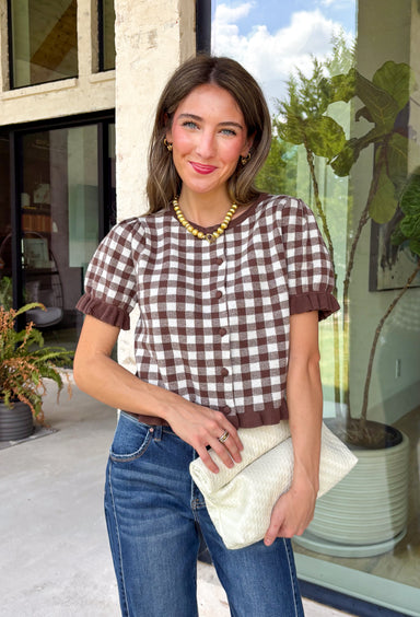 Sweet, timeless, and full of charm, this gingham cardigan is the perfect layer for the season! Featuring a classic brown and white gingham pattern, this button-down knit is finished with darling ruffle details on the sleeves and hem for an extra feminine touch. The soft, cozy knit makes it easy to wear on its own or layered over your favorite basics, creating an effortlessly polished look you'll love from weekday outings to weekend brunch.