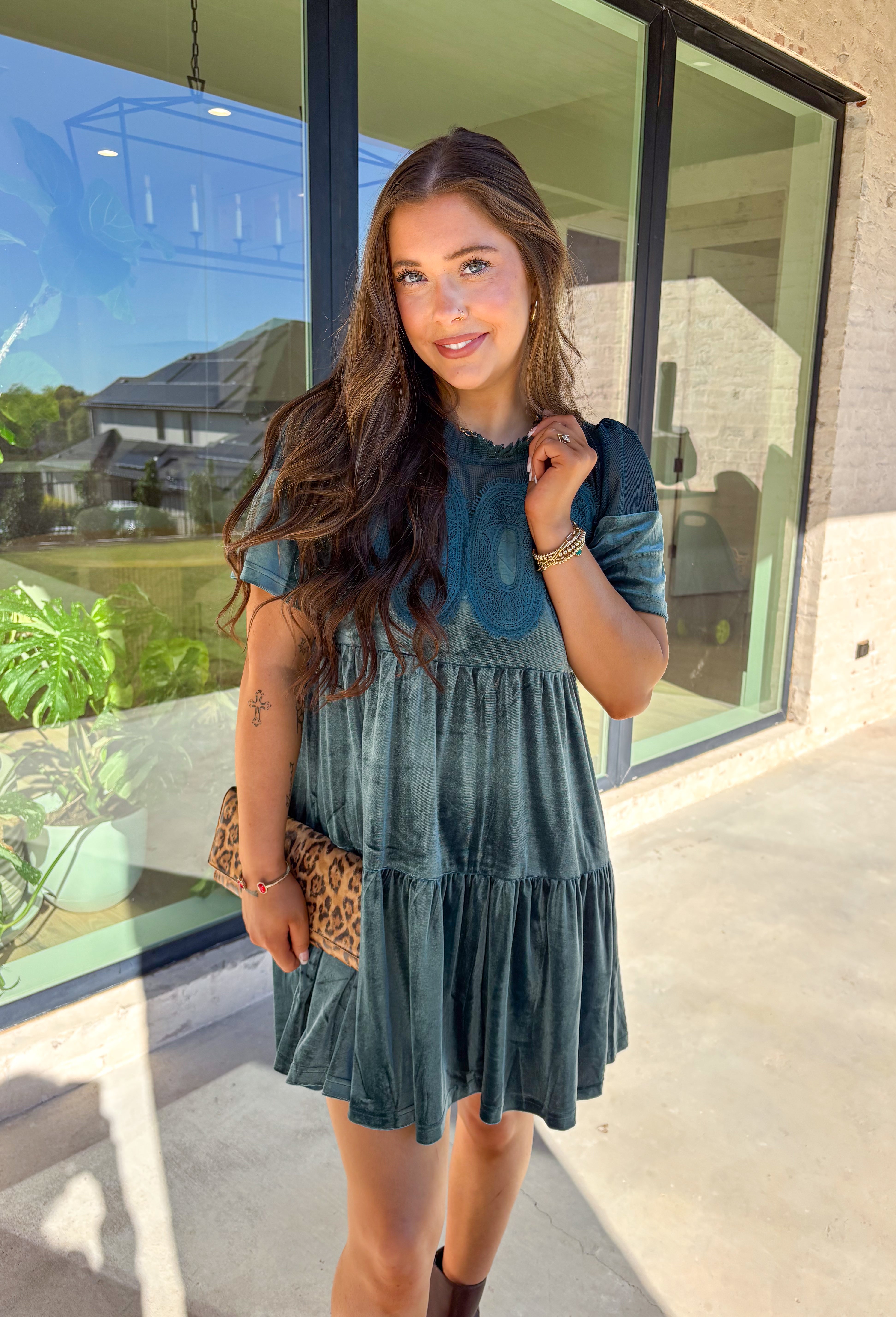 This tiered teal green crushed velvet dress by Fate is a showstopper for the season. Designed with rich texture and romantic details, it features open crochet accents along the top with oval-shaped embroidered lace appliqués for a stunning finish. The soft velvet fabric and fully lined interior make it as comfortable as it is elegant—perfect for the holiday season!