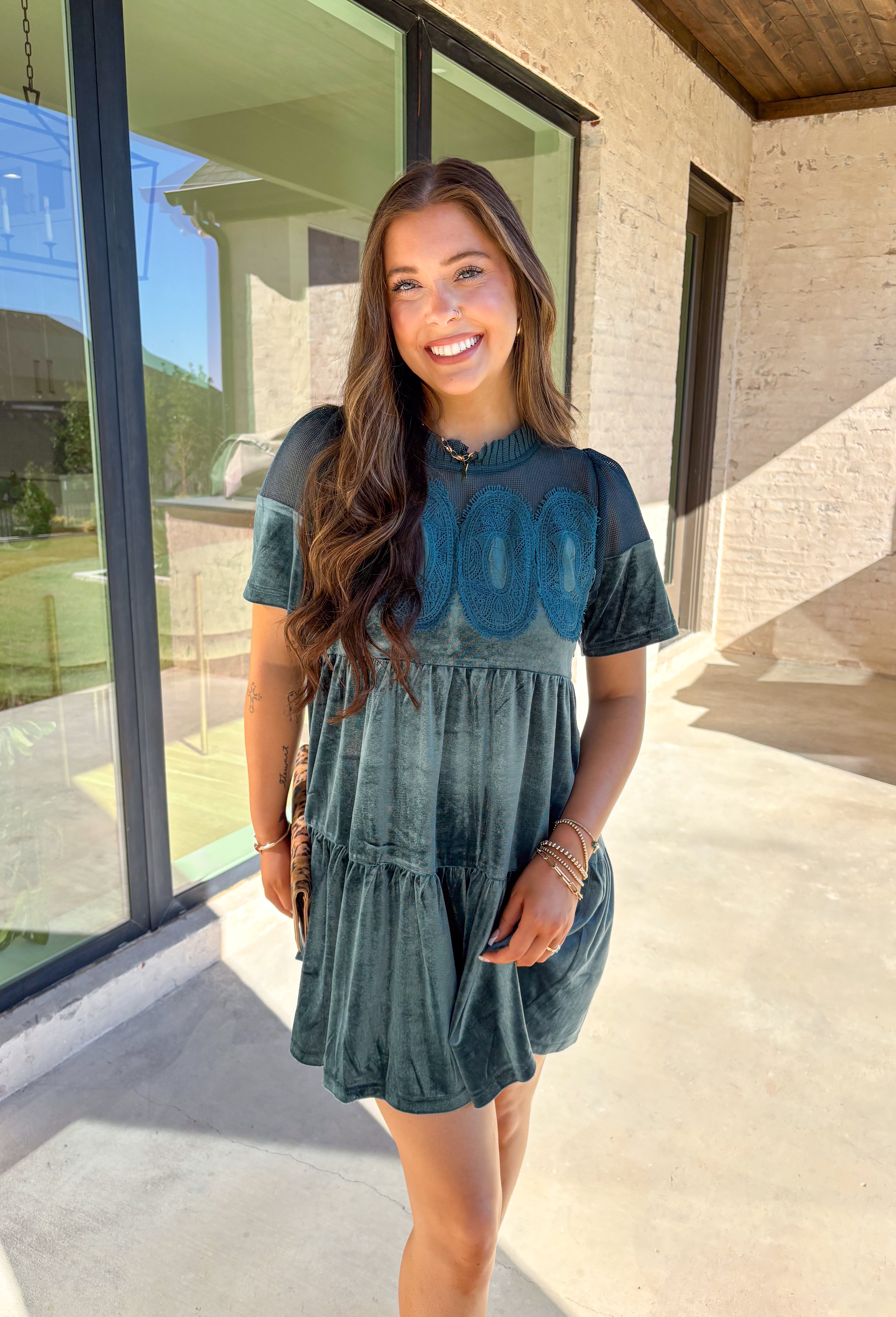 This tiered teal green crushed velvet dress by Fate is a showstopper for the season. Designed with rich texture and romantic details, it features open crochet accents along the top with oval-shaped embroidered lace appliqués for a stunning finish. The soft velvet fabric and fully lined interior make it as comfortable as it is elegant—perfect for the holiday season!