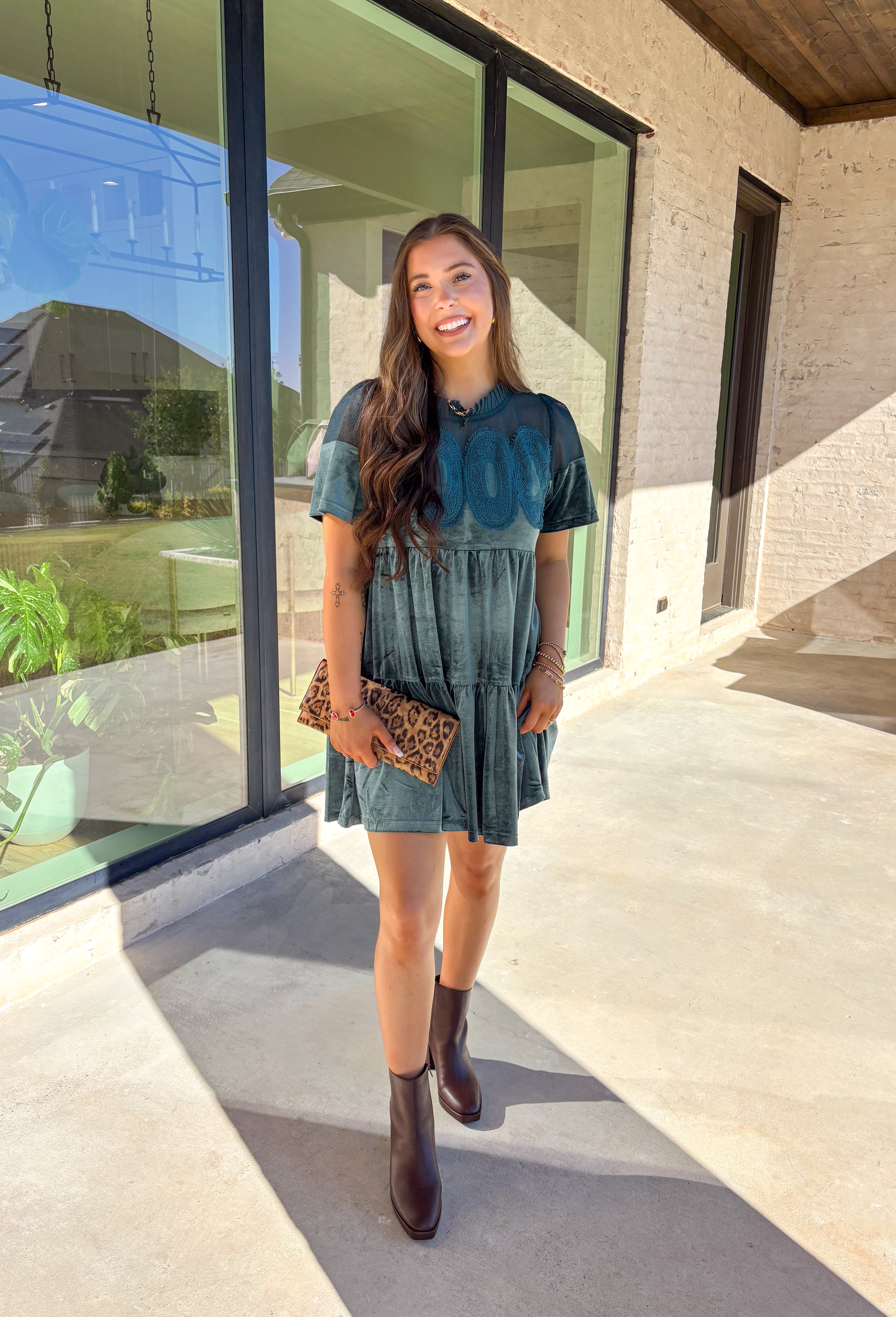 This tiered teal green crushed velvet dress by Fate is a showstopper for the season. Designed with rich texture and romantic details, it features open crochet accents along the top with oval-shaped embroidered lace appliqués for a stunning finish. The soft velvet fabric and fully lined interior make it as comfortable as it is elegant—perfect for the holiday season!