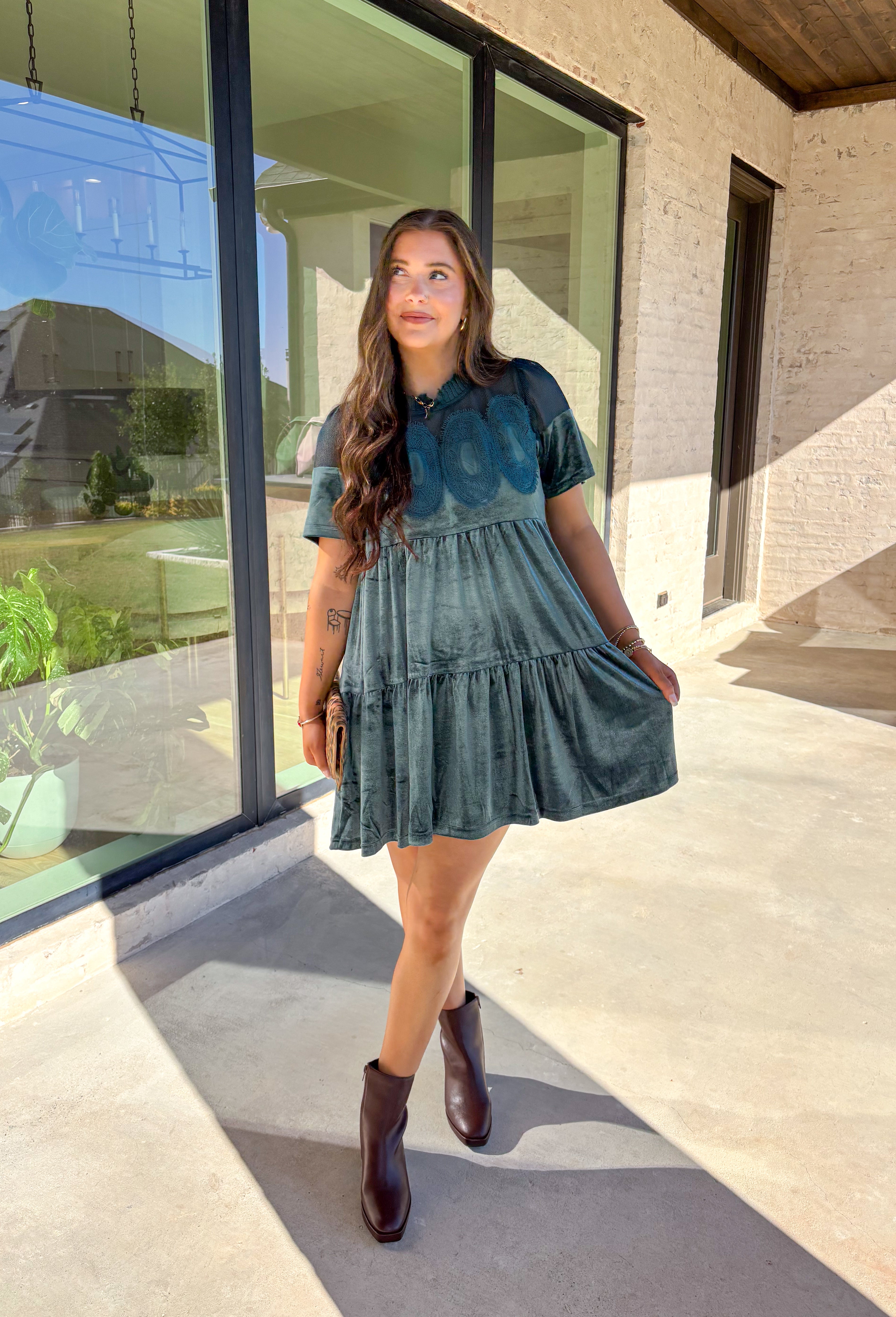 This tiered teal green crushed velvet dress by Fate is a showstopper for the season. Designed with rich texture and romantic details, it features open crochet accents along the top with oval-shaped embroidered lace appliqués for a stunning finish. The soft velvet fabric and fully lined interior make it as comfortable as it is elegant—perfect for the holiday season!