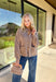 Warm, polished, and easy to wear—this brown knit cardigan is the perfect cozy layer for fall. The mock neck keeps the look refined, while hammered gold-tone buttons add a touch of shine to the button-front closure. Front pockets make it as practical as it is stylish, and the soft knit blend with a hint of wool offers just the right amount of warmth for crisp days. Whether layered over a dress or paired with jeans, it’s a seasonal staple you’ll reach for again and again.