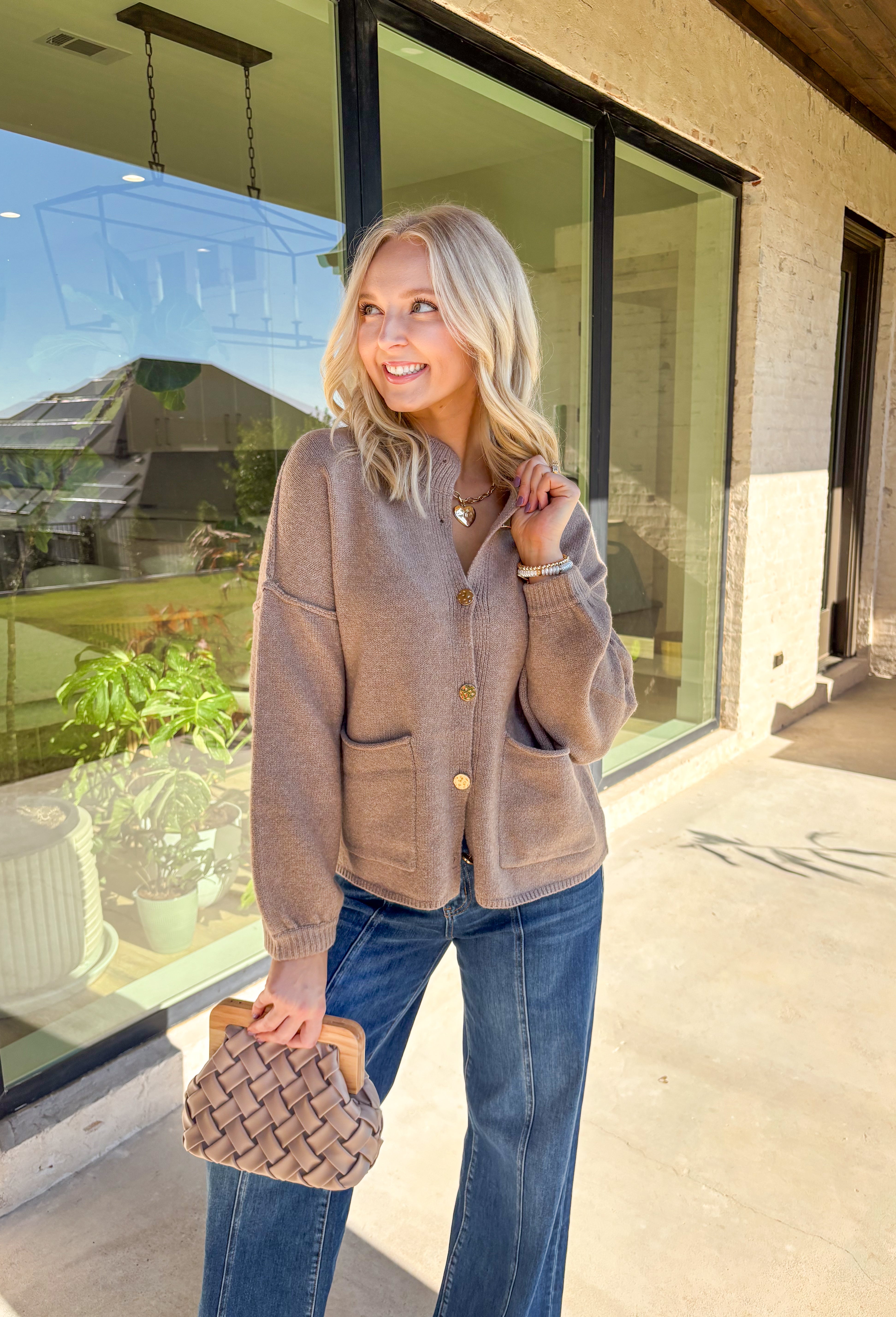 Warm, polished, and easy to wear—this brown knit cardigan is the perfect cozy layer for fall. The mock neck keeps the look refined, while hammered gold-tone buttons add a touch of shine to the button-front closure. Front pockets make it as practical as it is stylish, and the soft knit blend with a hint of wool offers just the right amount of warmth for crisp days. Whether layered over a dress or paired with jeans, it’s a seasonal staple you’ll reach for again and again.