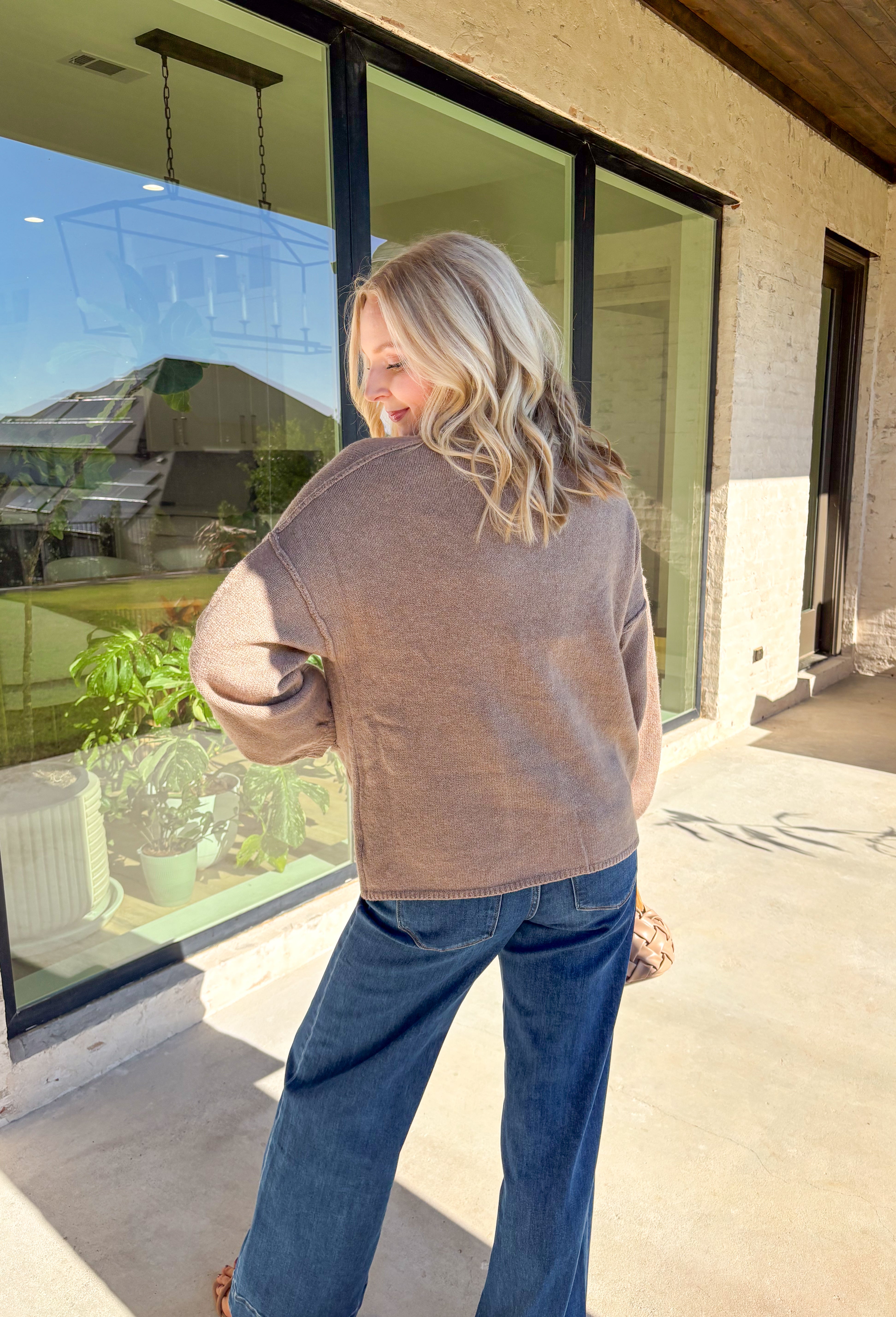 Warm, polished, and easy to wear—this brown knit cardigan is the perfect cozy layer for fall. The mock neck keeps the look refined, while hammered gold-tone buttons add a touch of shine to the button-front closure. Front pockets make it as practical as it is stylish, and the soft knit blend with a hint of wool offers just the right amount of warmth for crisp days. Whether layered over a dress or paired with jeans, it’s a seasonal staple you’ll reach for again and again.