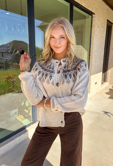 Add a pop of cozy charm to your wardrobe with this chunky knit button-down cardigan by Blu Pepper. Featuring a round neckline and long sleeves, it’s designed with a vibrant Fair Isle pattern in neutral tones—making it an easy piece to mix and match with your seasonal staples. Finished with a button-front closure, it’s just as easy to wear open as it is closed, giving you endless layering possibilities. Warm yet breathable, this cardigan is perfect for styling through the season.