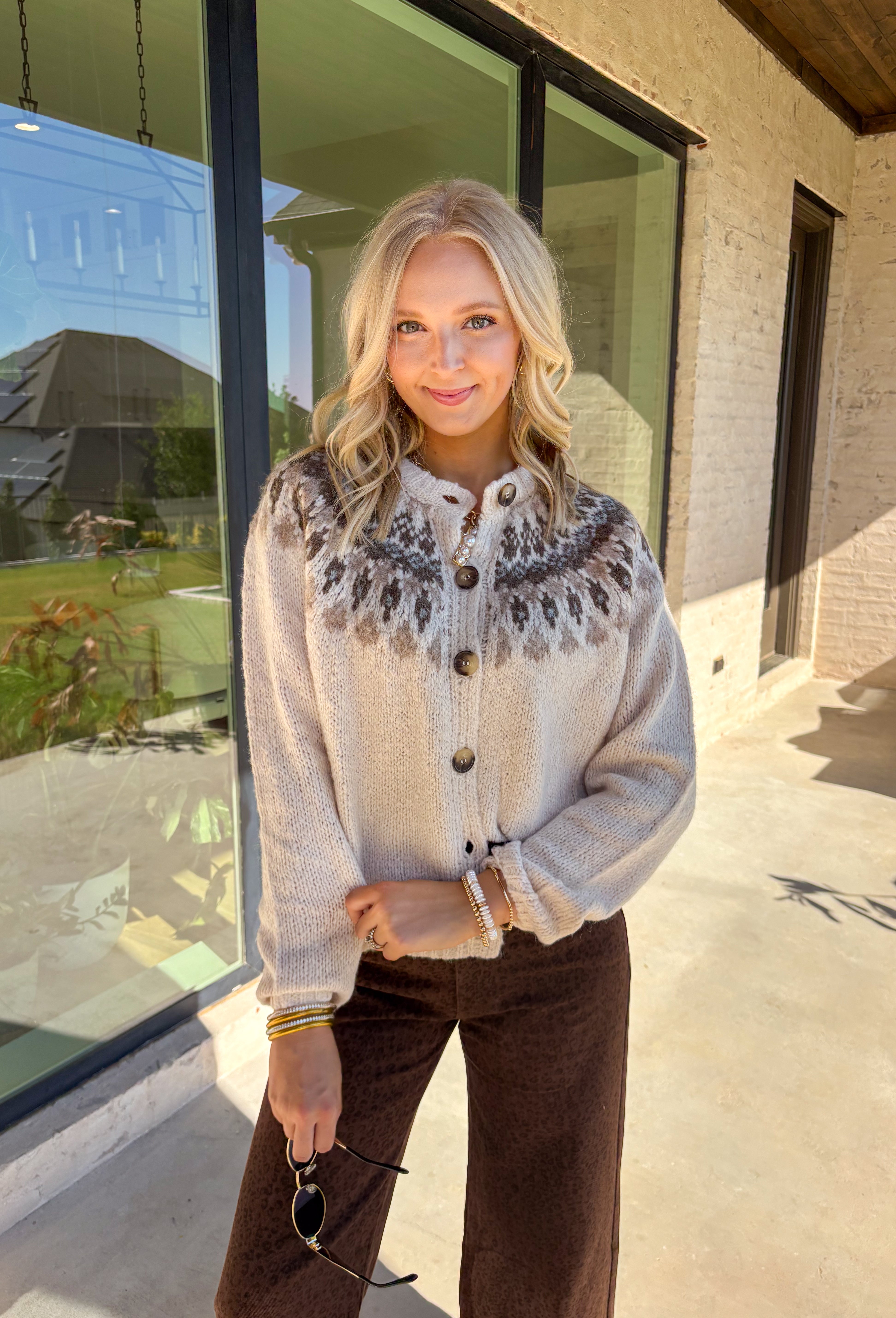 Add a pop of cozy charm to your wardrobe with this chunky knit button-down cardigan by Blu Pepper. Featuring a round neckline and long sleeves, it’s designed with a vibrant Fair Isle pattern in neutral tones—making it an easy piece to mix and match with your seasonal staples. Finished with a button-front closure, it’s just as easy to wear open as it is closed, giving you endless layering possibilities. Warm yet breathable, this cardigan is perfect for styling through the season.