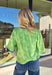 Fresh, fun, and full of texture, this green short sleeve top by Voy is an easy spring standout. Designed with a monochromatic textured floral print, it adds dimension and detail while keeping the look clean and wearable. Royal blue embroidered trim along the front, cuffs, and hem gives it a bold pop of contrast, and the square neckline adds a flattering, modern finish. Lightweight and easy to style, this top is perfect for brightening up your everyday spring outfits.
