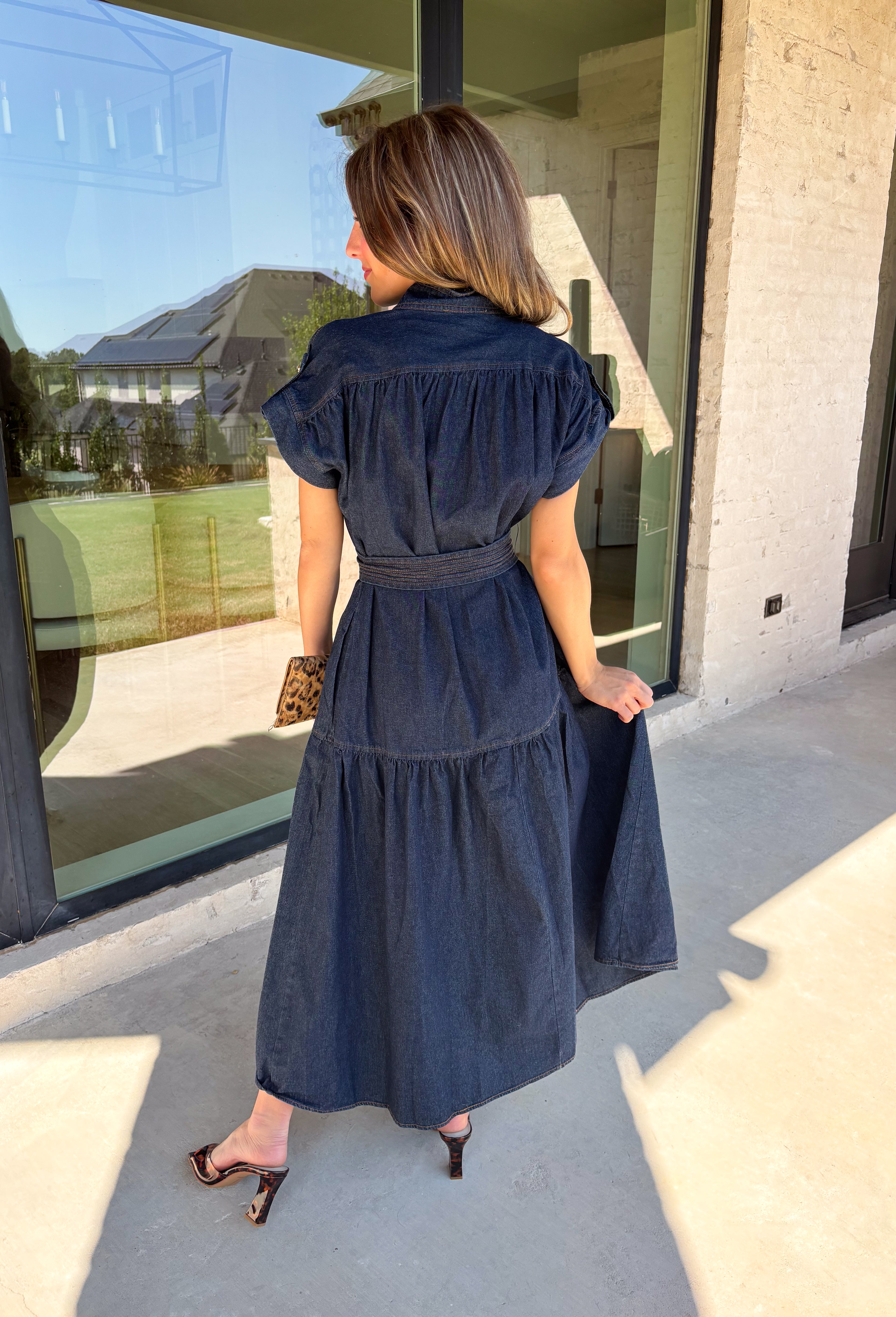 There’s something about a great denim dress that makes getting dressed feel instantly easier. This dark wash midi dress from Entro features a stand collar and partial gold button front that adds a polished touch to the classic denim look. Cap sleeves keep the silhouette easy to layer as the seasons change, while the coordinating self-tie belt lets you add definition at the waist. Finished with convenient side pockets, this versatile dress can take you from casual office days and lunch plans to football week