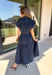 There’s something about a great denim dress that makes getting dressed feel instantly easier. This dark wash midi dress from Entro features a stand collar and partial gold button front that adds a polished touch to the classic denim look. Cap sleeves keep the silhouette easy to layer as the seasons change, while the coordinating self-tie belt lets you add definition at the waist. Finished with convenient side pockets, this versatile dress can take you from casual office days and lunch plans to football week