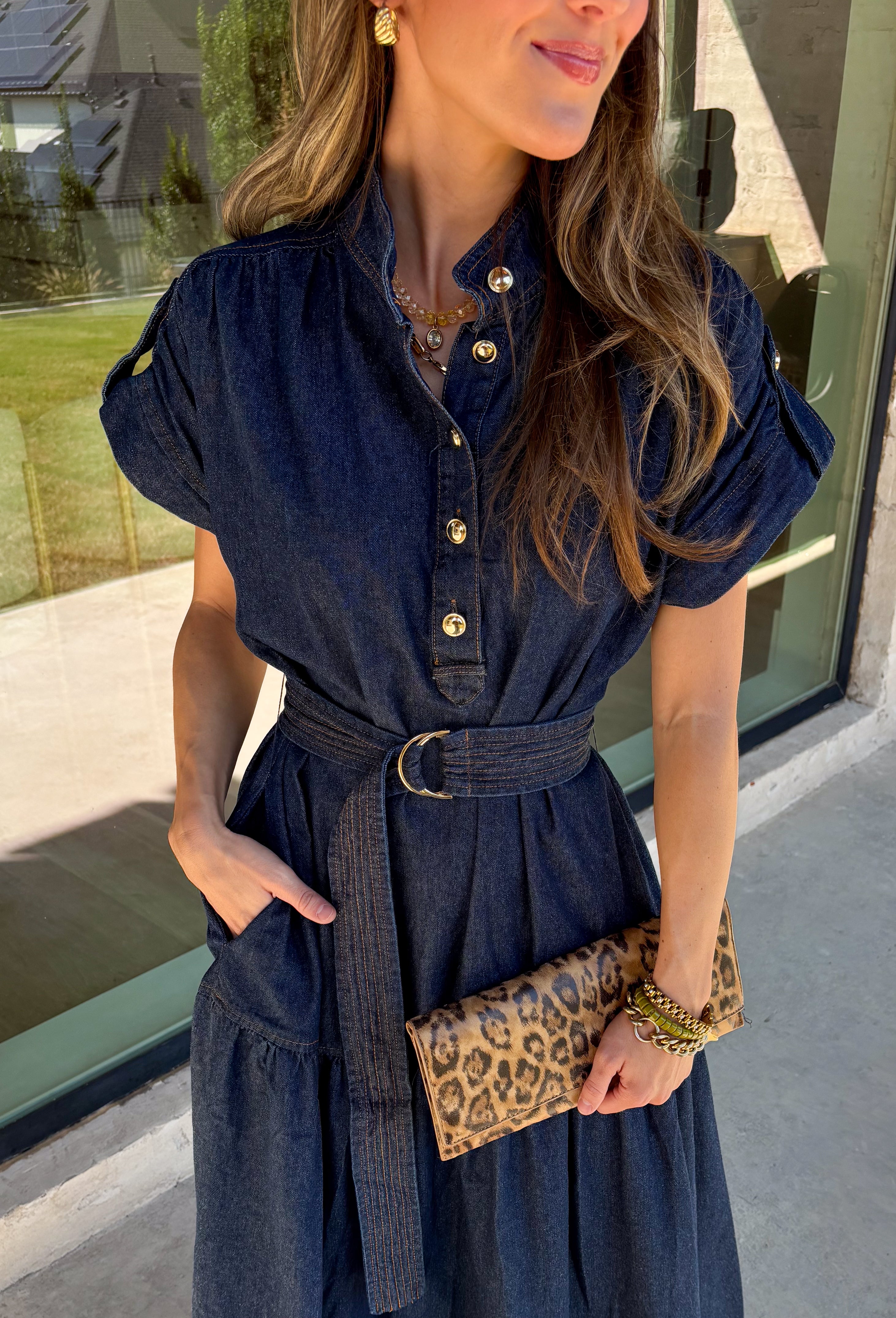 There’s something about a great denim dress that makes getting dressed feel instantly easier. This dark wash midi dress from Entro features a stand collar and partial gold button front that adds a polished touch to the classic denim look. Cap sleeves keep the silhouette easy to layer as the seasons change, while the coordinating self-tie belt lets you add definition at the waist. Finished with convenient side pockets, this versatile dress can take you from casual office days and lunch plans to football week
