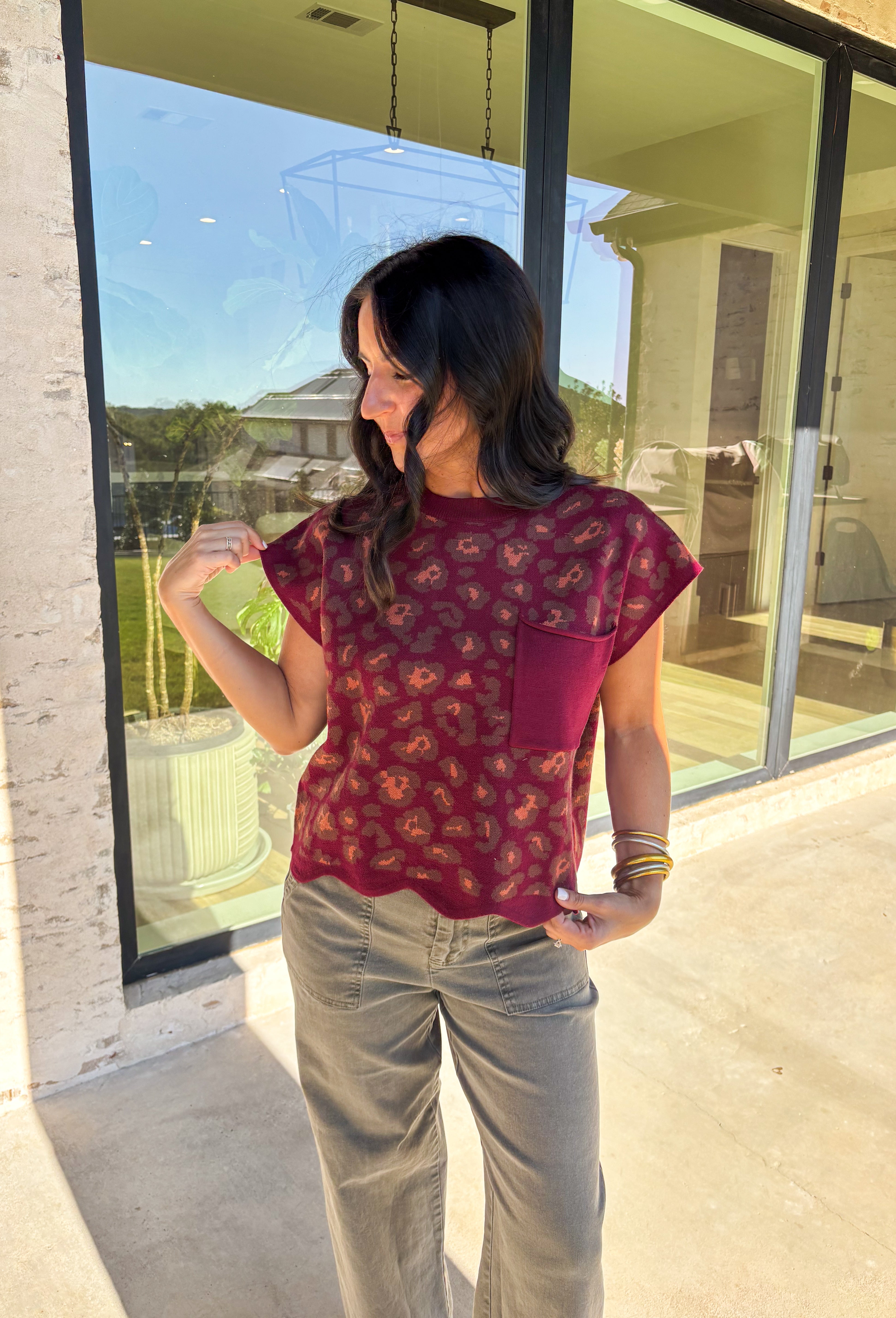 This burgundy short sleeve sweater from Entro adds a touch of fun to your fall lineup. Designed with a playful leopard print and a chest patch pocket, it’s finished with a scalloped edge hem for a feminine twist. The soft knit fabric keeps it cozy yet lightweight—perfect for layering or wearing solo as the seasons shift.