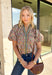 Bring a fresh take on fall florals to your wardrobe with this beautifully detailed top from Entro. Designed with a soft light blue backdrop and a floral print in rich autumn shades, this feminine blouse is full of charming details. Blue and olive contrast trim along the front adds a unique pop of color, while the subtle ruffle neckline and puff sleeves create a timeless, polished silhouette. Crafted from breathable cotton, this versatile top is perfect for everything from workdays to weekend brunches.