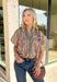 Bring a fresh take on fall florals to your wardrobe with this beautifully detailed top from Entro. Designed with a soft light blue backdrop and a floral print in rich autumn shades, this feminine blouse is full of charming details. Blue and olive contrast trim along the front adds a unique pop of color, while the subtle ruffle neckline and puff sleeves create a timeless, polished silhouette. Crafted from breathable cotton, this versatile top is perfect for everything from workdays to weekend brunches.