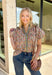 Bring a fresh take on fall florals to your wardrobe with this beautifully detailed top from Entro. Designed with a soft light blue backdrop and a floral print in rich autumn shades, this feminine blouse is full of charming details. Blue and olive contrast trim along the front adds a unique pop of color, while the subtle ruffle neckline and puff sleeves create a timeless, polished silhouette. Crafted from breathable cotton, this versatile top is perfect for everything from workdays to weekend brunches.