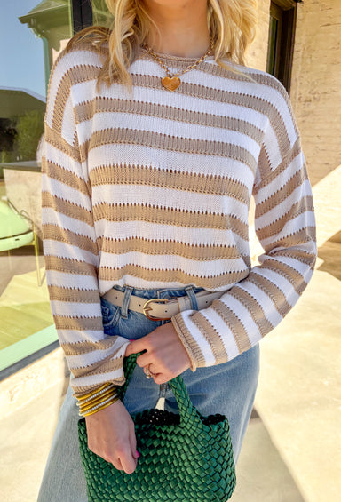 Lightweight, breezy, and perfect for spring layering, this taupe and white striped sweater by Wishlist is an effortless staple. The open knit design keeps it airy and easy to wear, making it ideal for mild days and cool evenings. With classic stripes and a relaxed fit, it’s the kind of sweater you can toss on over a tank, swimsuit, or dress and instantly look put together.