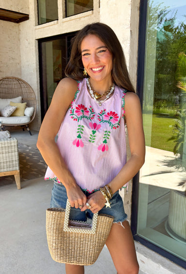 This light pink stripe tank is the sweetest mix of playful and feminine for summer! Featuring pink, red, and green floral embroidery, it adds the prettiest pop of color against the soft striped base. The scalloped hem and sleeves give it that extra delicate detail, while the side tie accents and keyhole back keep it feeling unique and thoughtfully designed. Lightweight and breathable in 100% cotton, it’s perfect for warm days when you want to feel cute and put together. 