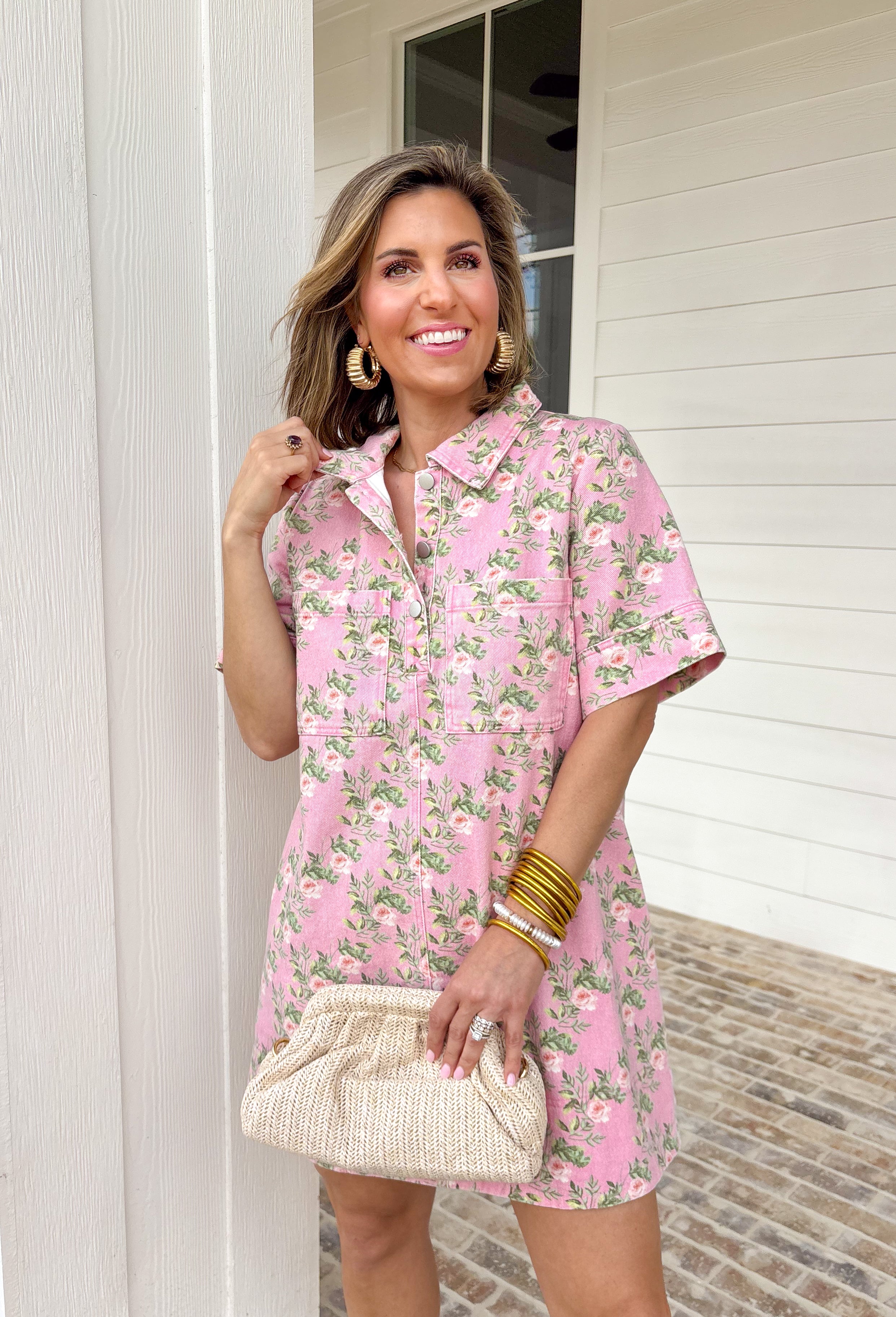 Soft denim meets spring florals in this light pink short sleeve dress by Entro. Featuring a pretty floral print throughout in shades of pink and green, this dress feels fresh, cheerful, and easy to wear. The collared neckline and front button details give it a classic, polished look, while front and side pockets keep it practical for everyday wear. Made from a comfortable stretch denim, this dress is perfect for spring days when you want something cute, comfortable, and effortlessly put together.