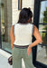 Elevate your everyday style with this timeless sweater knit that's equal parts classic and versatile. Crafted in an off-white knit with striking black and brown contrast trim, this sleeveless sweater offers a polished look you'll wear on repeat all season long. The button-front design makes it easy to style on its own or layered over a fitted long sleeve when temperatures start to cool. Whether you're heading to the office, brunch, or a weekend outing, this piece brings effortless charm to any outfit.