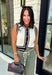 Elevate your everyday style with this timeless sweater knit that's equal parts classic and versatile. Crafted in an off-white knit with striking black and brown contrast trim, this sleeveless sweater offers a polished look you'll wear on repeat all season long. The button-front design makes it easy to style on its own or layered over a fitted long sleeve when temperatures start to cool. Whether you're heading to the office, brunch, or a weekend outing, this piece brings effortless charm to any outfit.