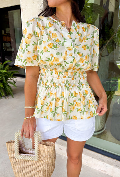 This neutral floral top is such a bright and easy pick for summer days! The soft yellow floral print with subtle pops of green gives it that fresh, feel-good look that’s perfect for the season. The smocked elastic waist creates a flattering shape while still keeping things comfortable and easy to wear. Finished with a v-neckline, it has that effortless, feminine feel you’ll reach for again and again. Lightweight and breathable in cotton, it’s perfect for everything from errands to lunch plans. 